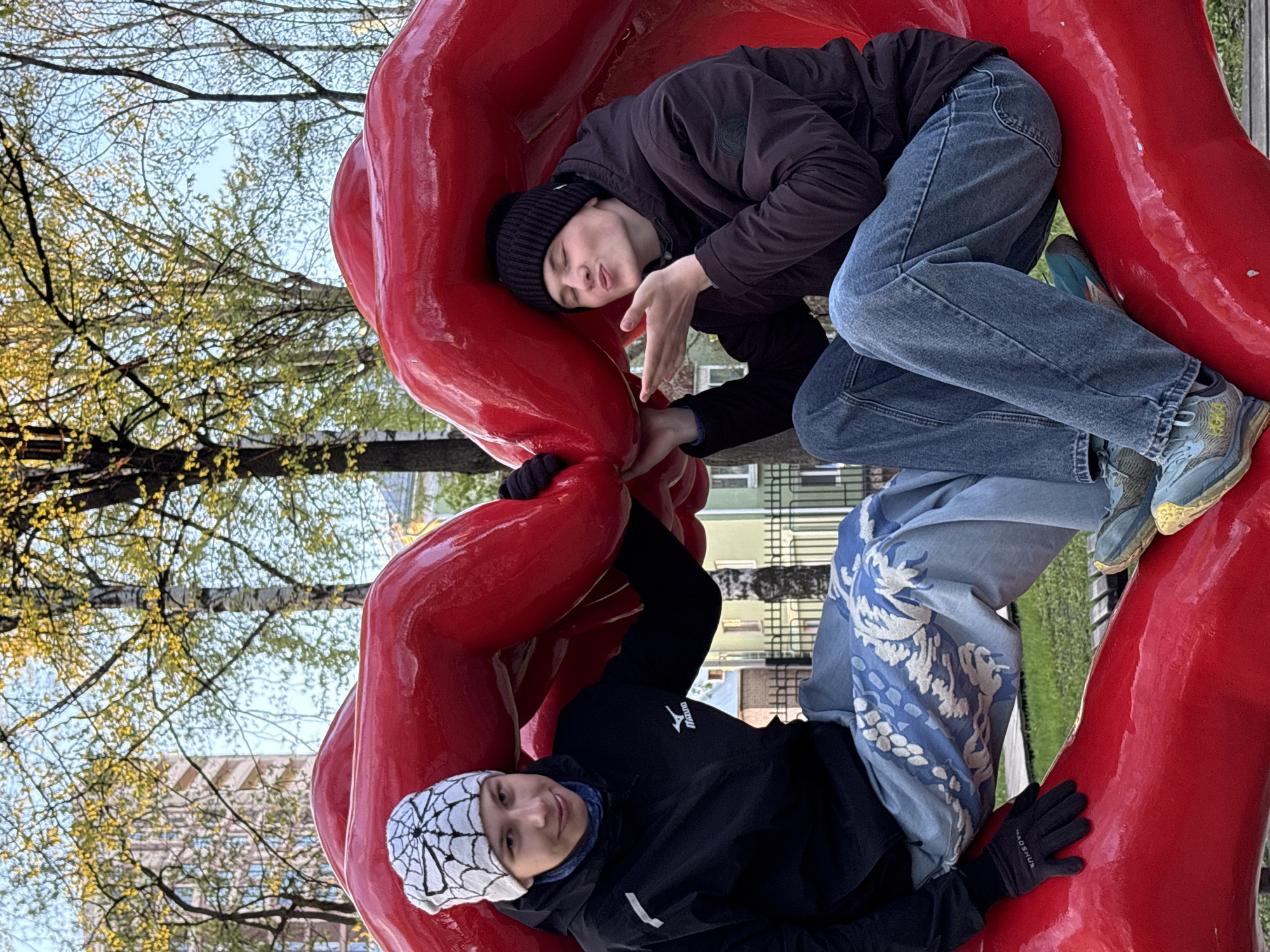Visitors interact with red public art sculptures in Perm