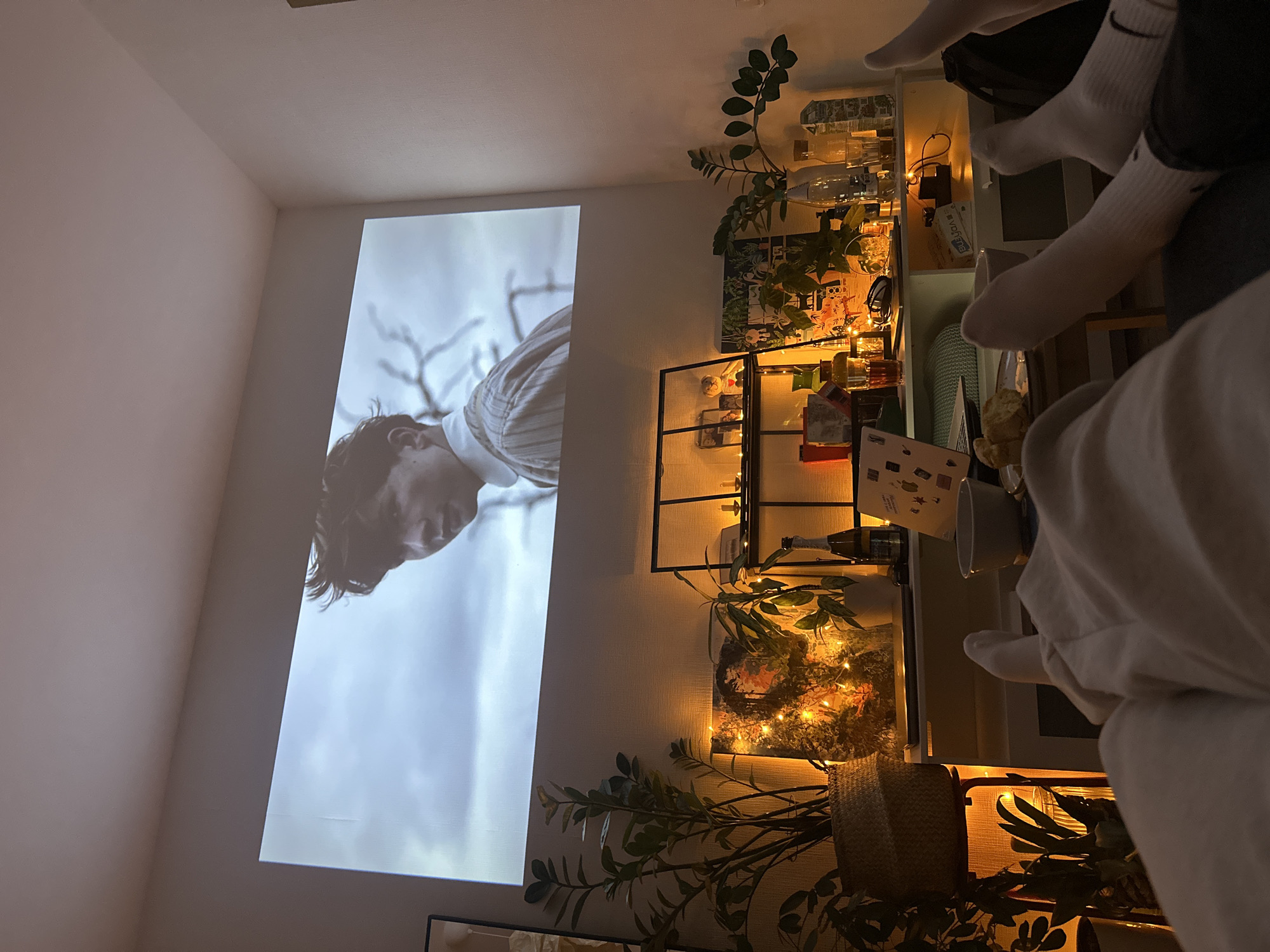 Indoor projection shows man against sky backdrop on wall