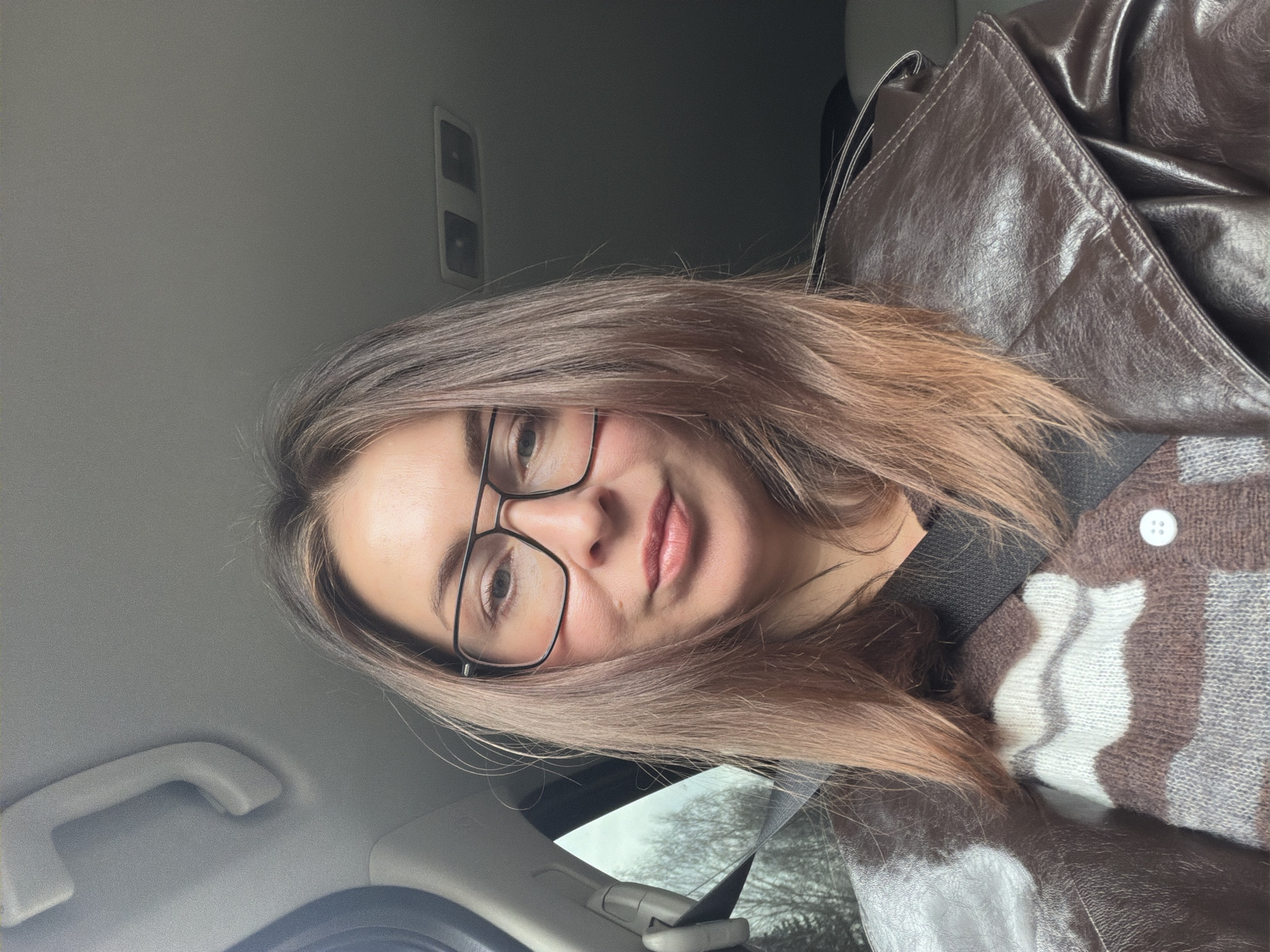 Woman takes selfies in car while passenger rests