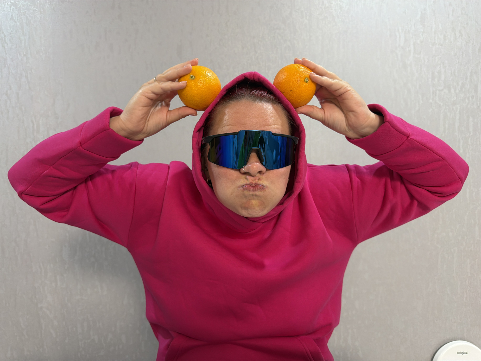 Person plays with oranges as ears in playful moment
