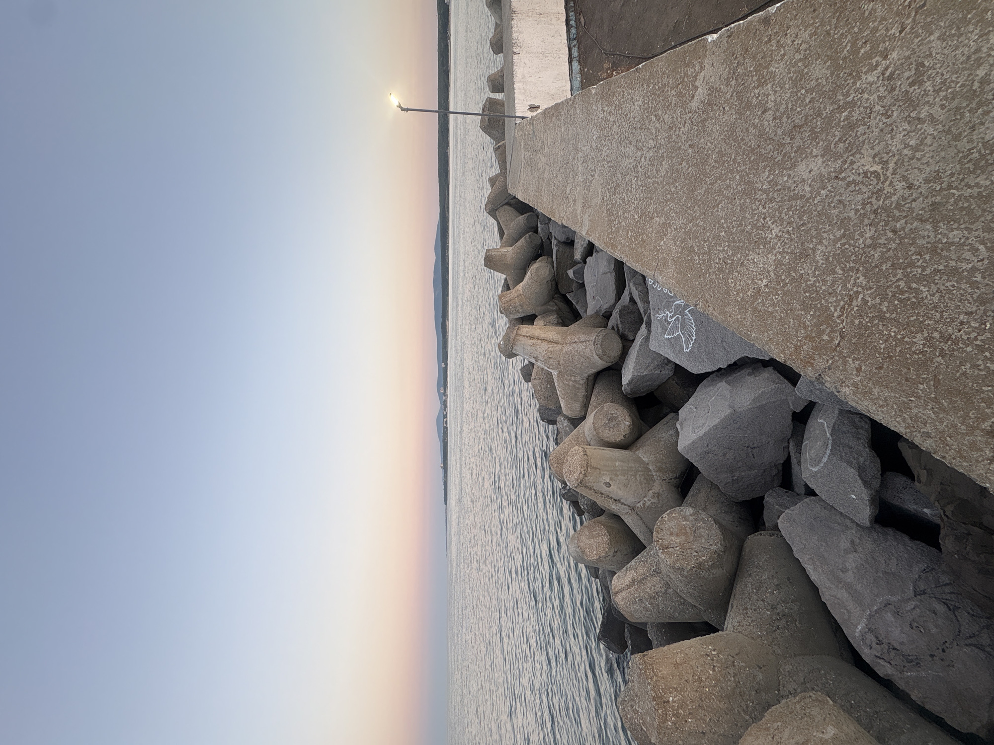 Dusk settles over Primorsko's rocky breakwater on the Black Sea