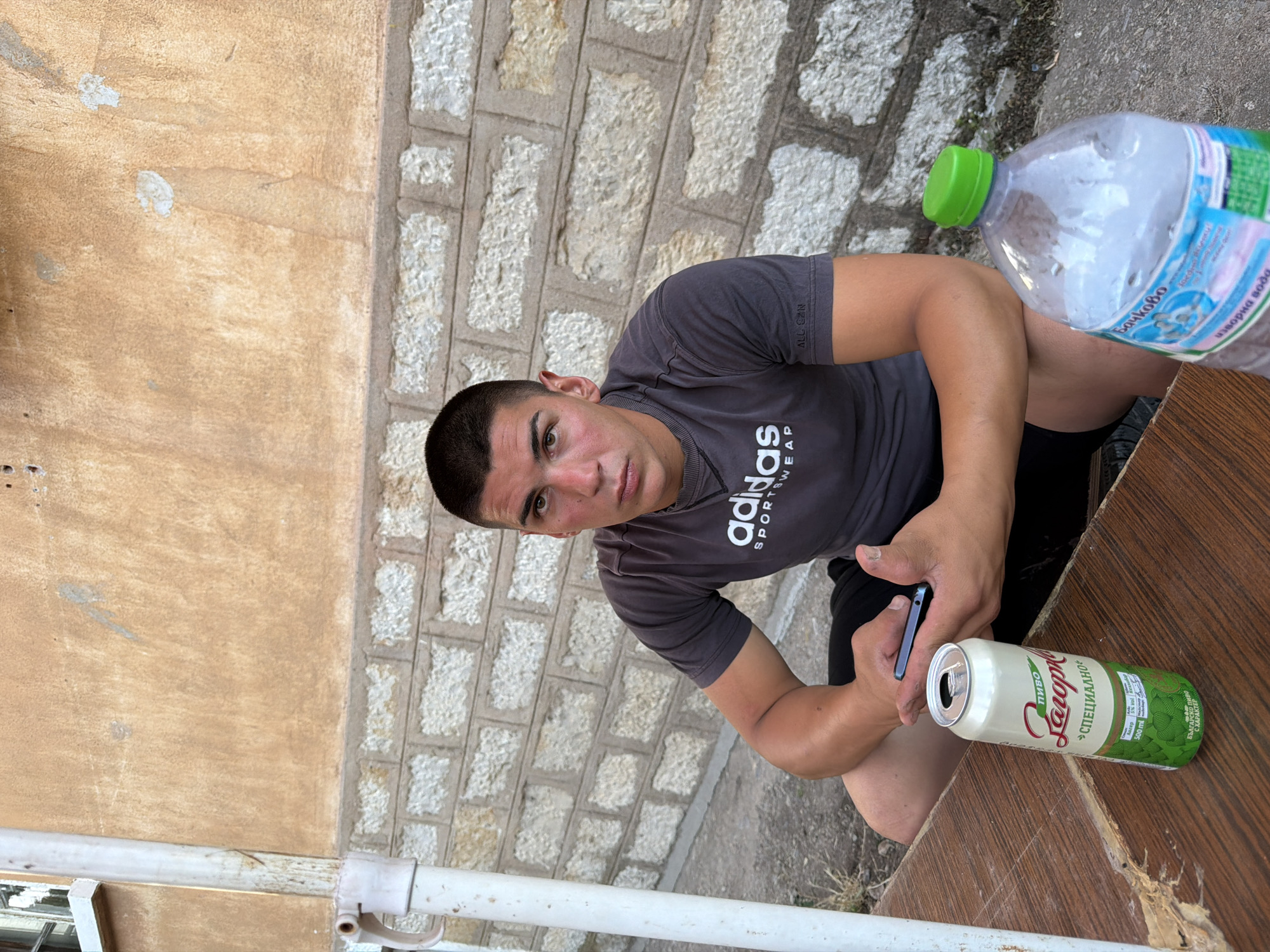 Outdoor table, open beer, phone in hand — Vratsa evening