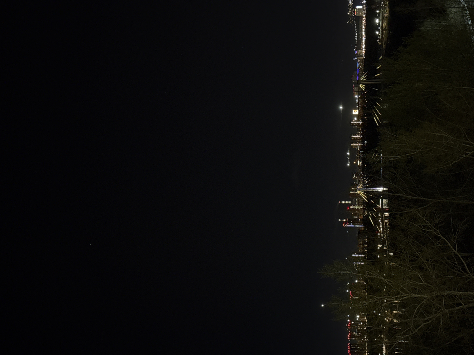 Nighttime cityscape captured in Krasnoyarsk showing illuminated bridge, waterway