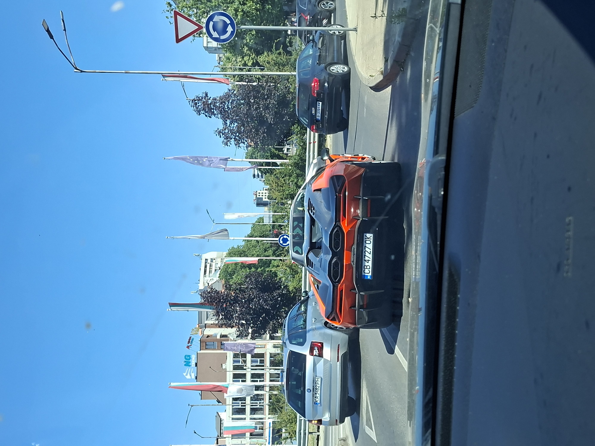 Orange sports car moving through sunny Varna streets