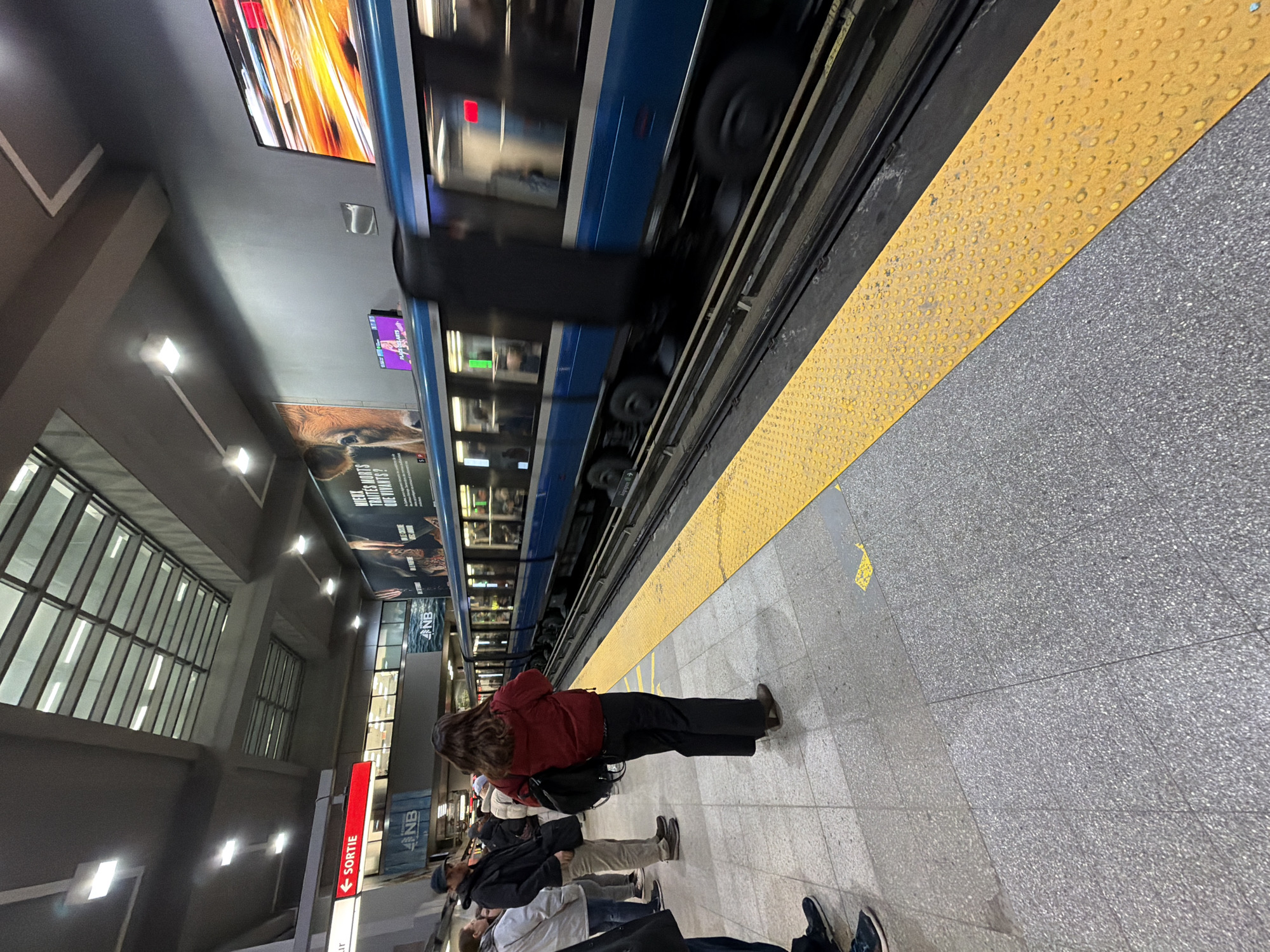 Blue metro train in motion at Montreal subway platform