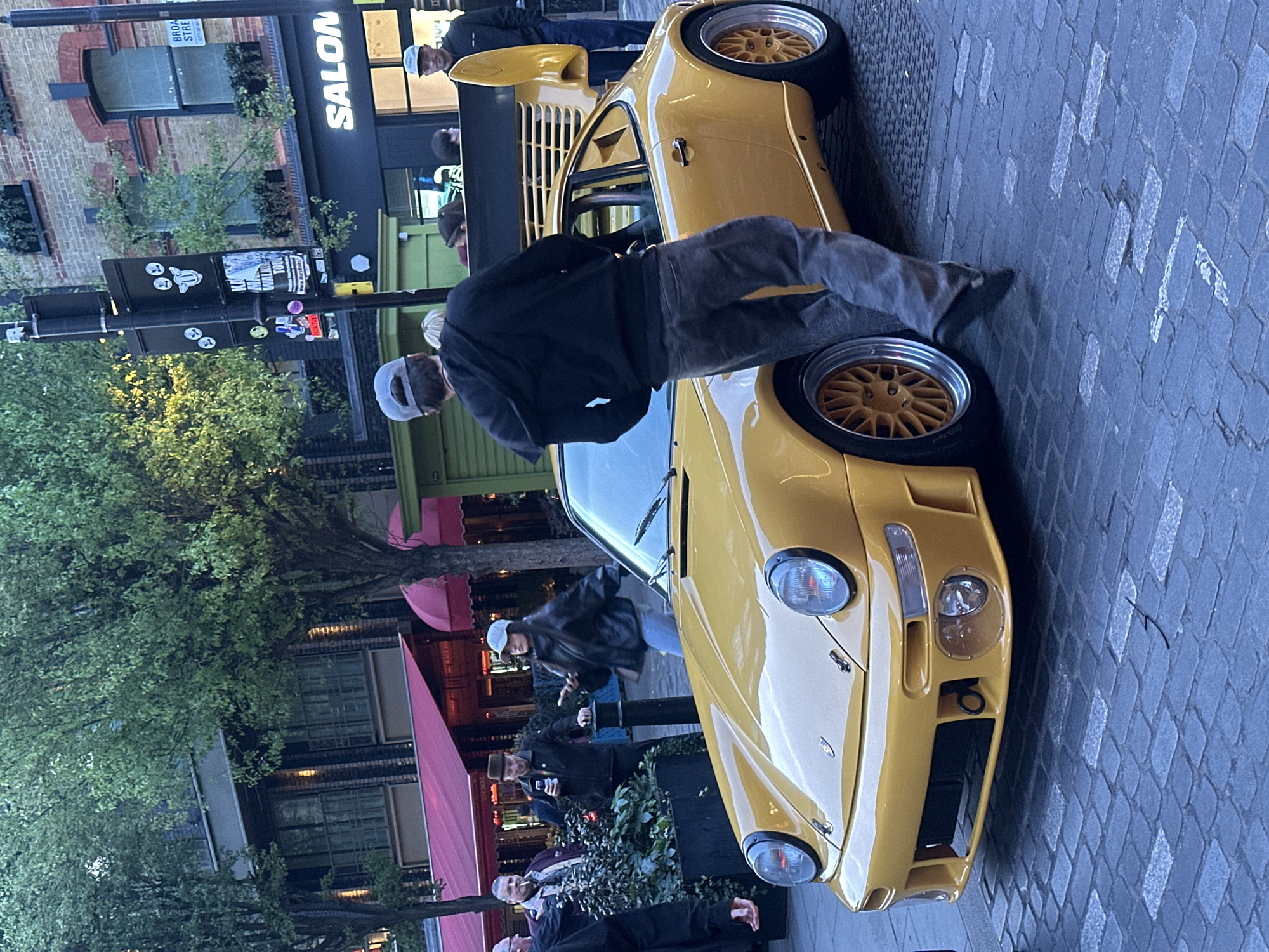 Yellow Porsche draws crowd on London cobblestone street