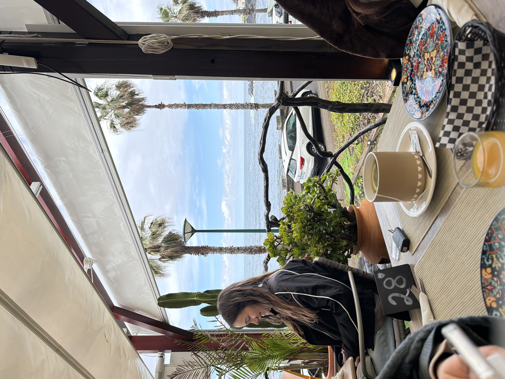 Woman enjoys breakfast at coastal cafe in Porto Moniz