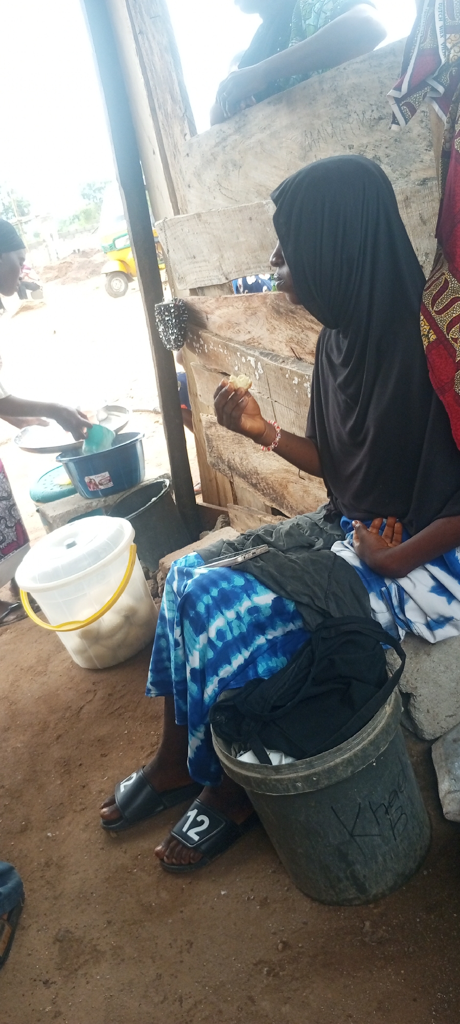 Woman tends to outdoor food stall in Zango-ndaji