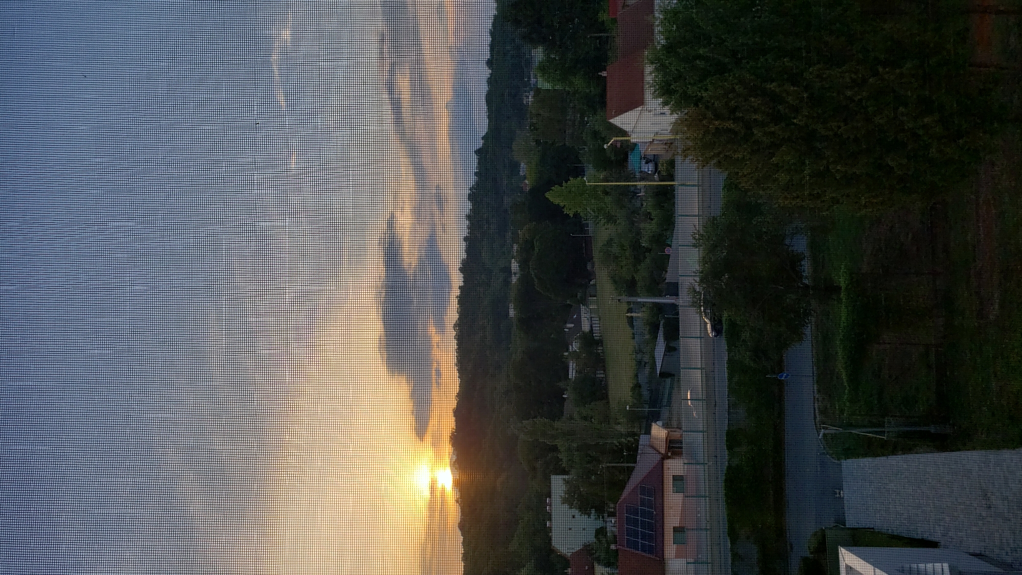 Sunset over Prešov's wooded hills, seen through an apartment window
