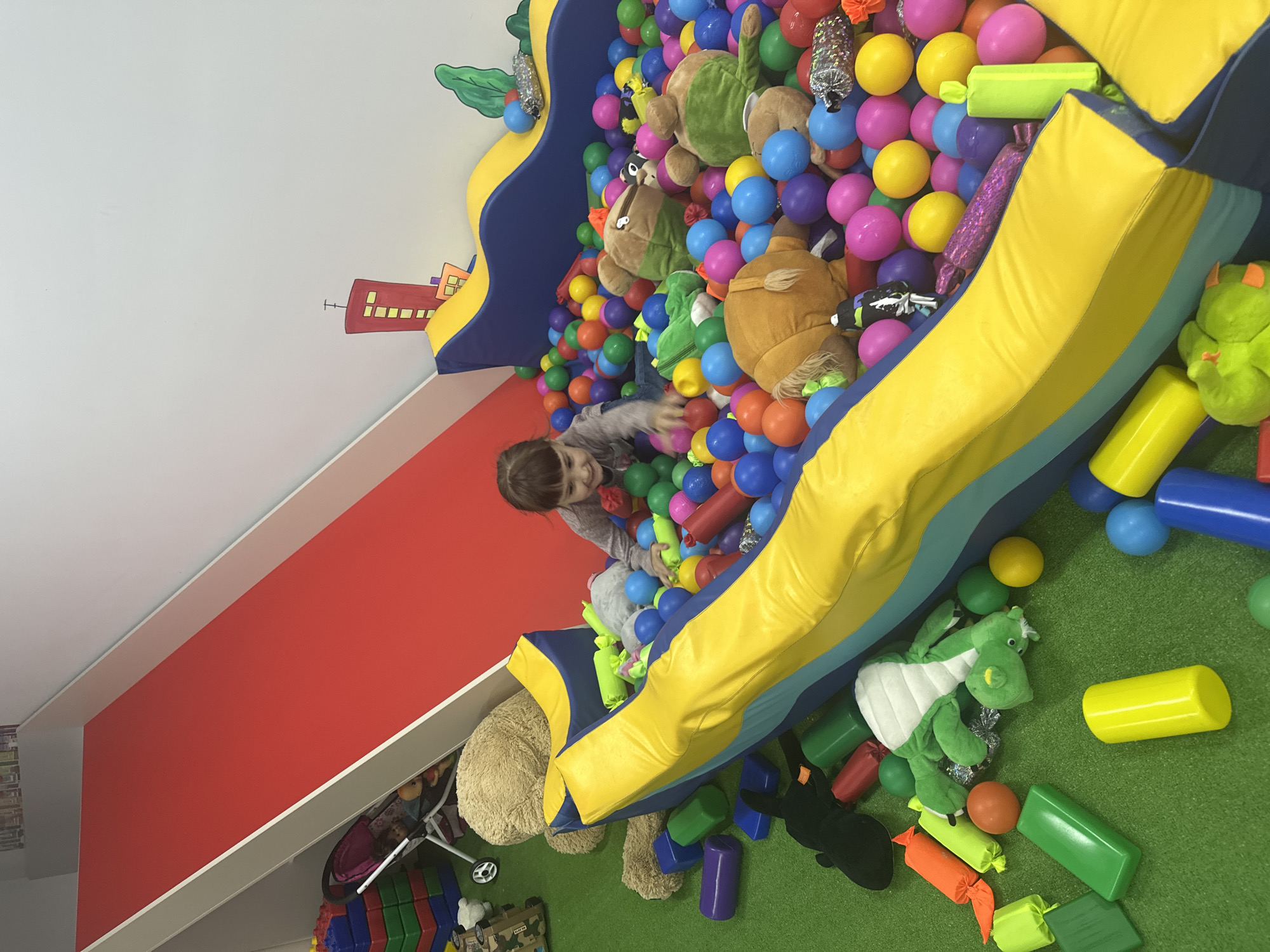 Children enjoy playtime with costumed entertainer at indoor venue