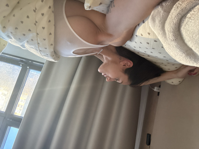 Woman rests in bed during morning hours in Khimki