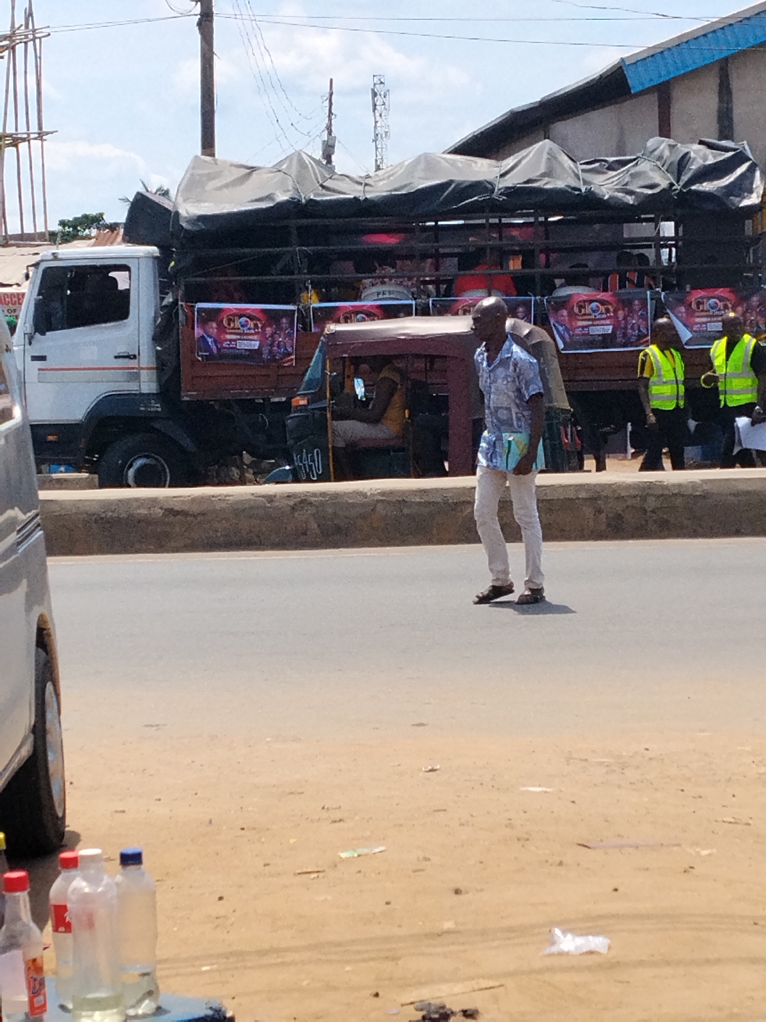 Man crosses street as passenger truck passes in Aba