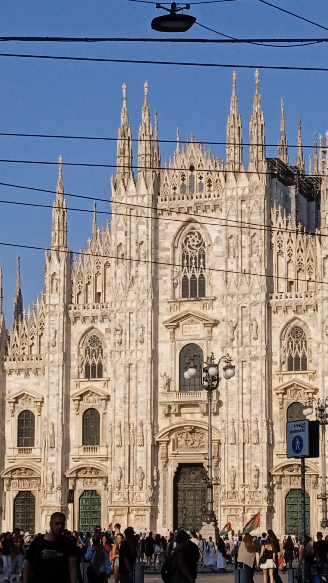 Milan's Duomo square buzzing on a clear summer afternoon