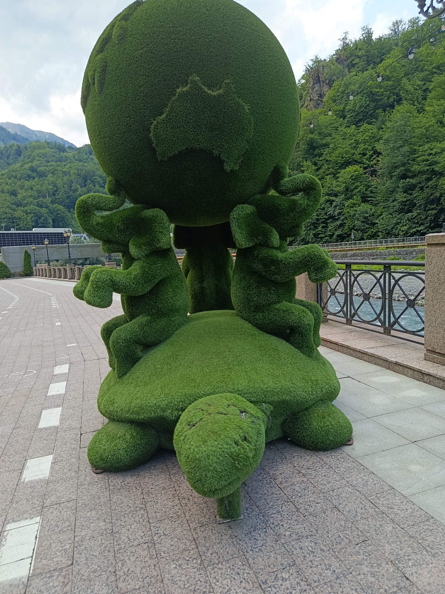 Estosadok resort park: topiaries, river, and scooters at the mountain base