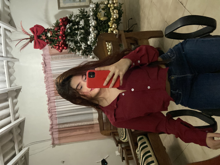 Woman takes selfies near Christmas tree in Juan Griego