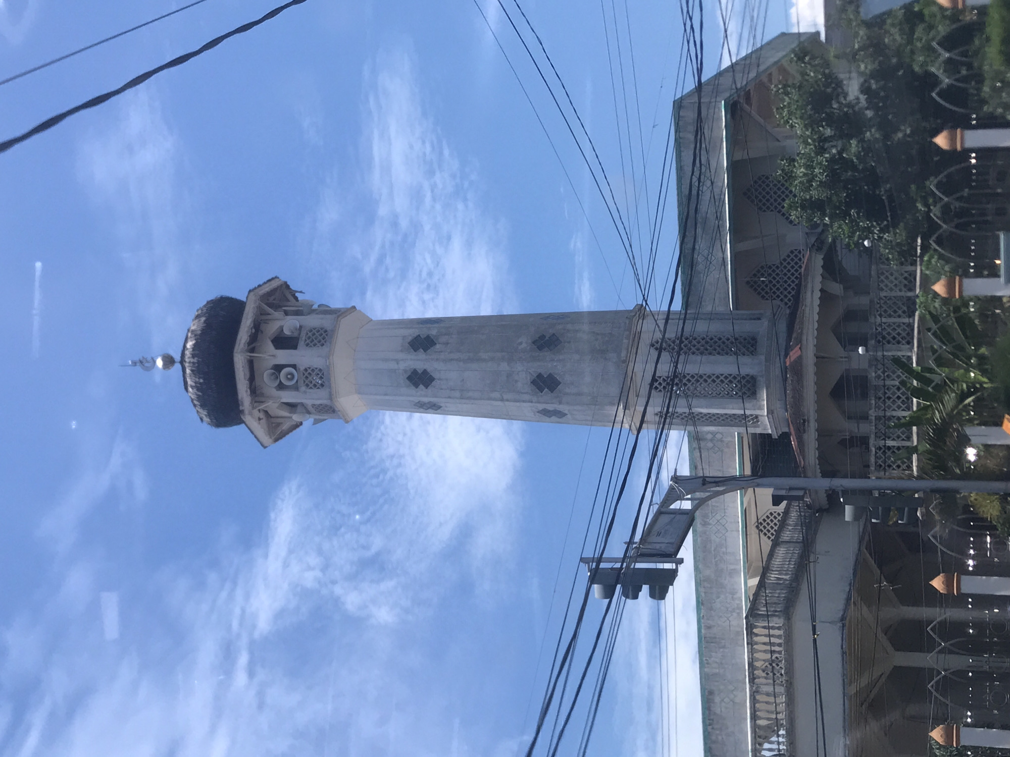 Mosque minaret photographed against blue sky in Lhokseumawe, Indonesia