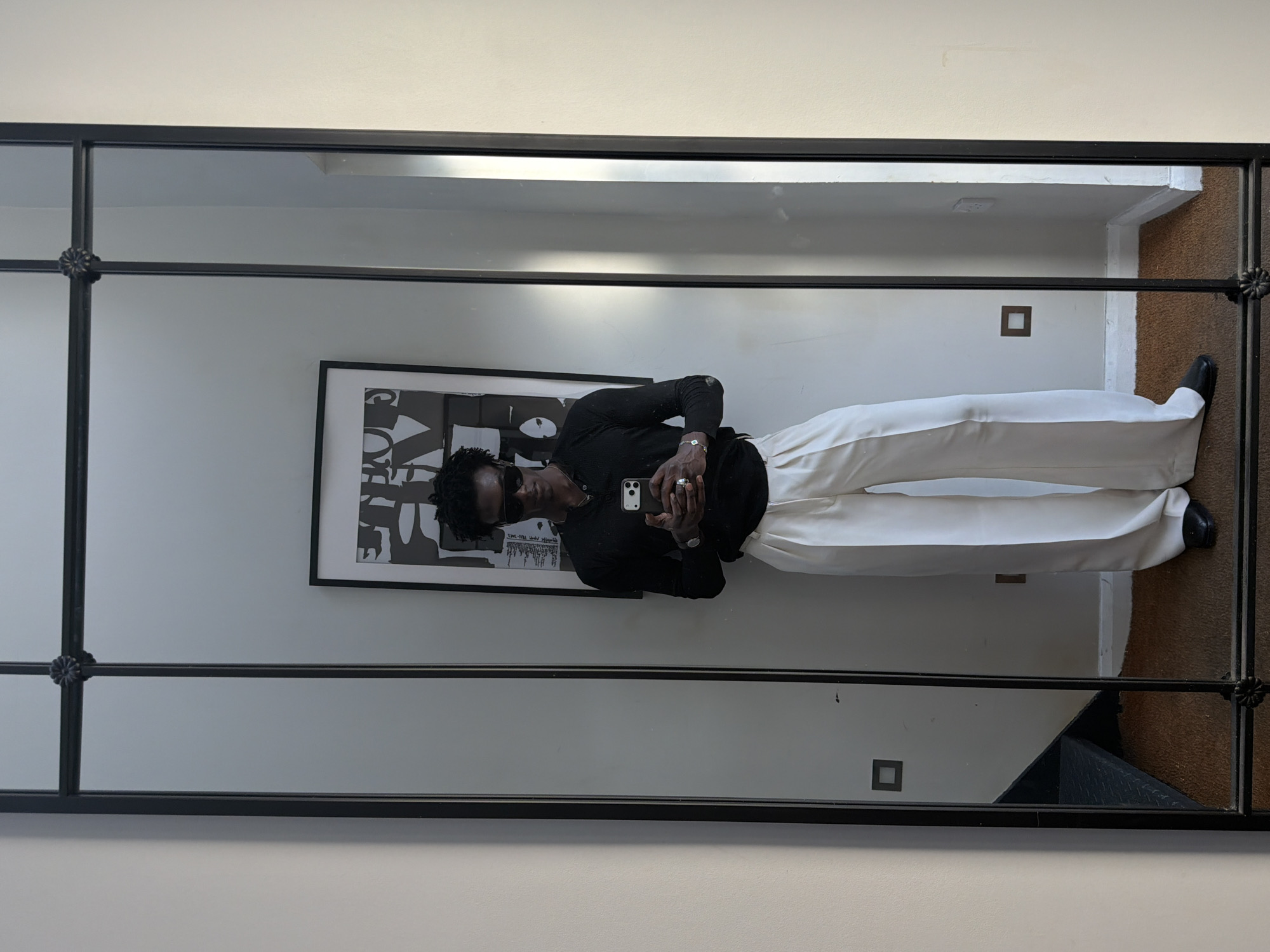 Person takes mirror selfies with artwork backdrop in London