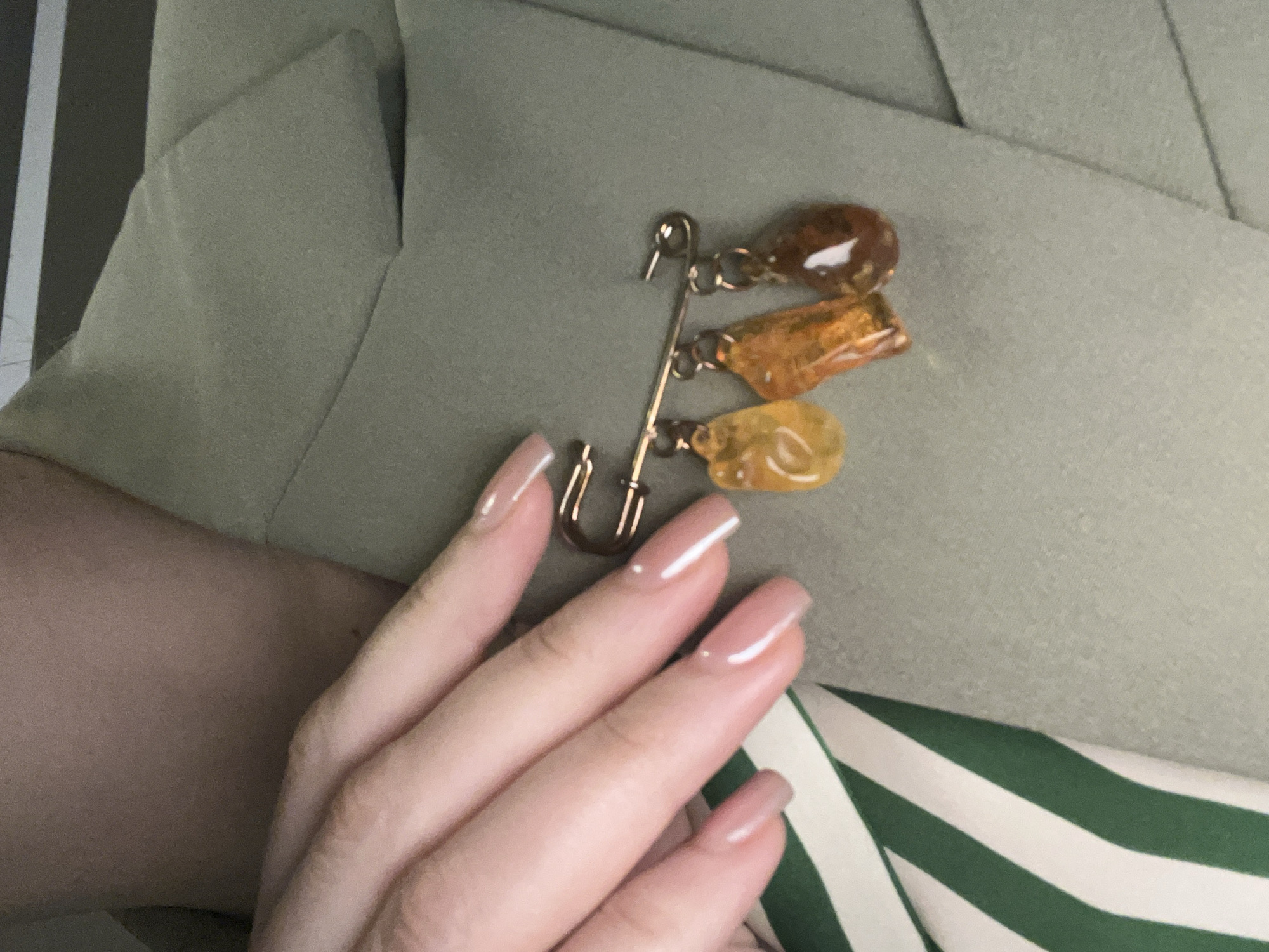 Person in green jacket with vintage brooch photographed in Podgorica