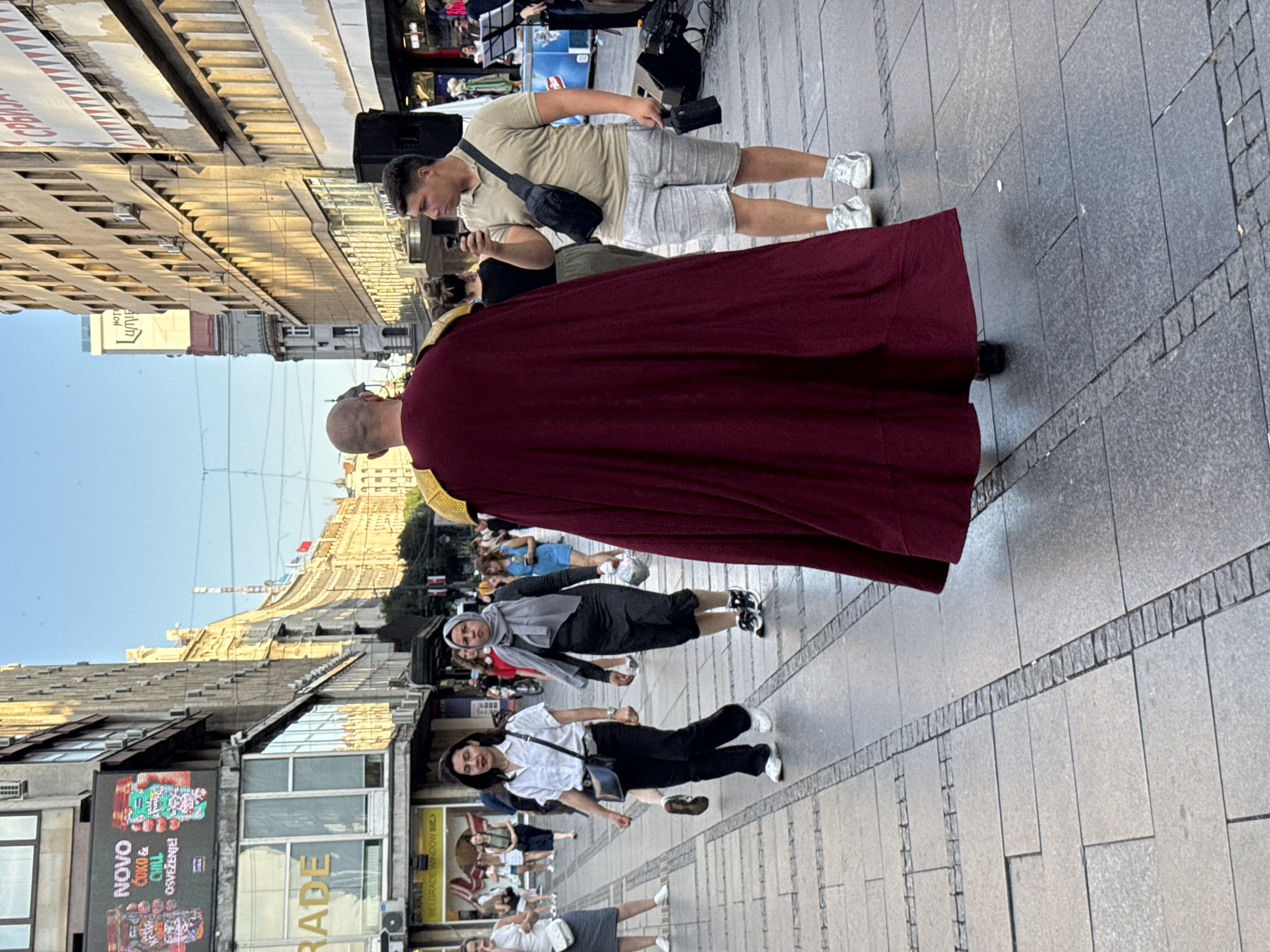 Robed figure strolling through Belgrade streets in summer