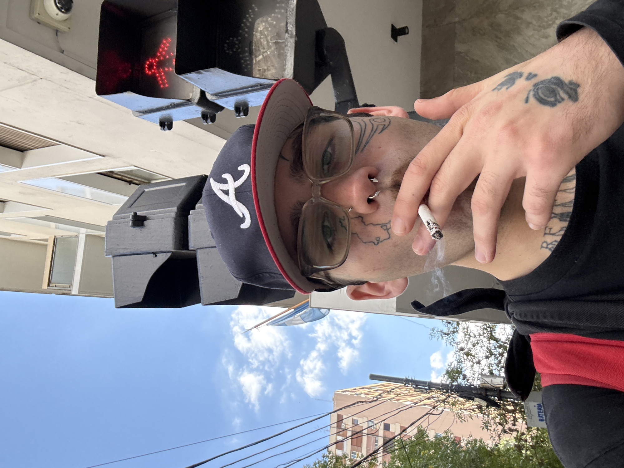Tattooed individual spotted smoking in Buenos Aires street scene