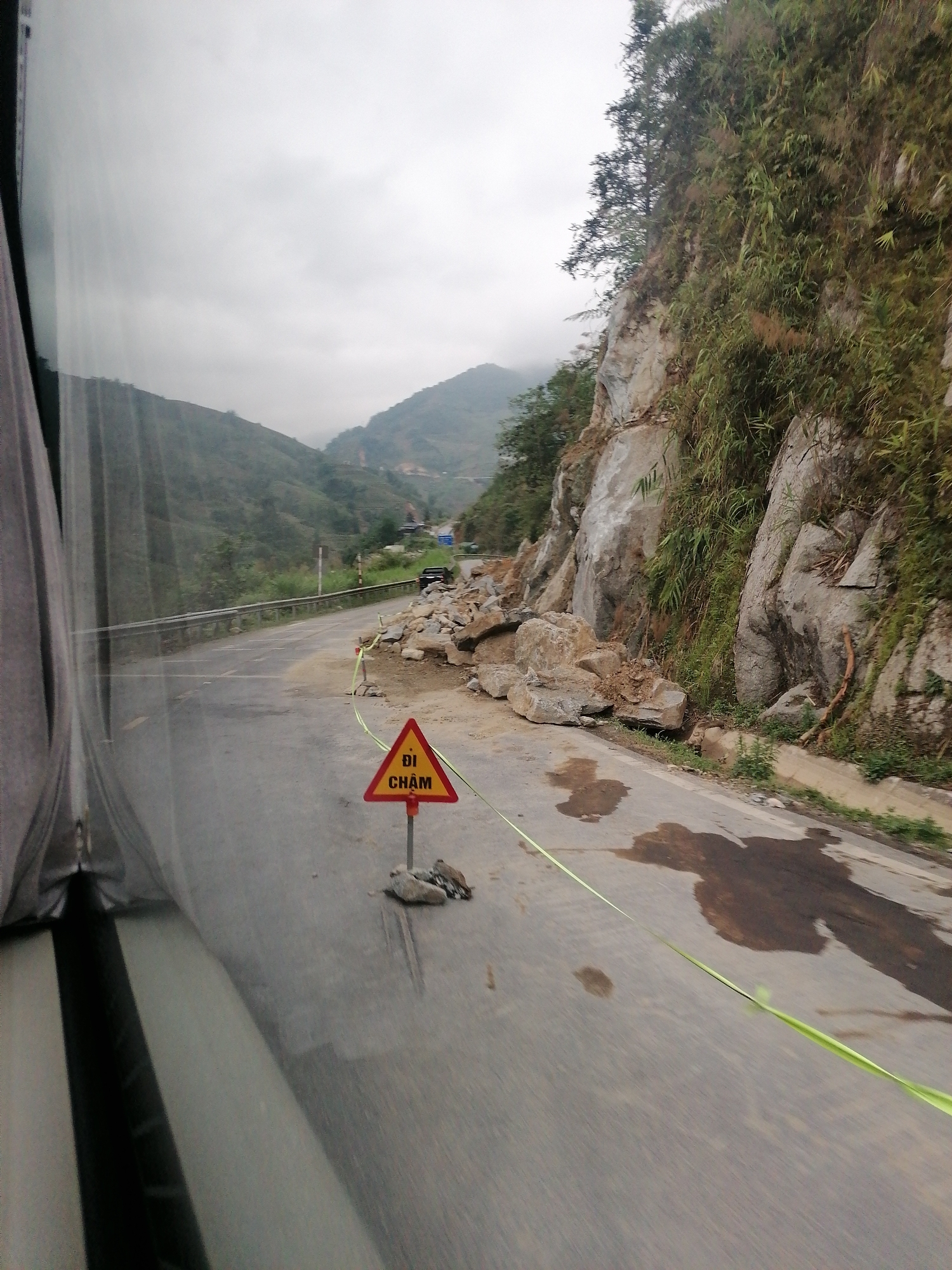 Mountain road partially blocked by rockslide, fog conditions reported