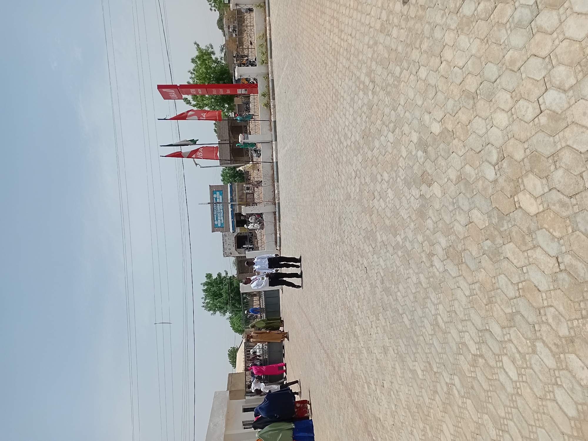 Men gather on tiled street in Dutsinma, Nigeria