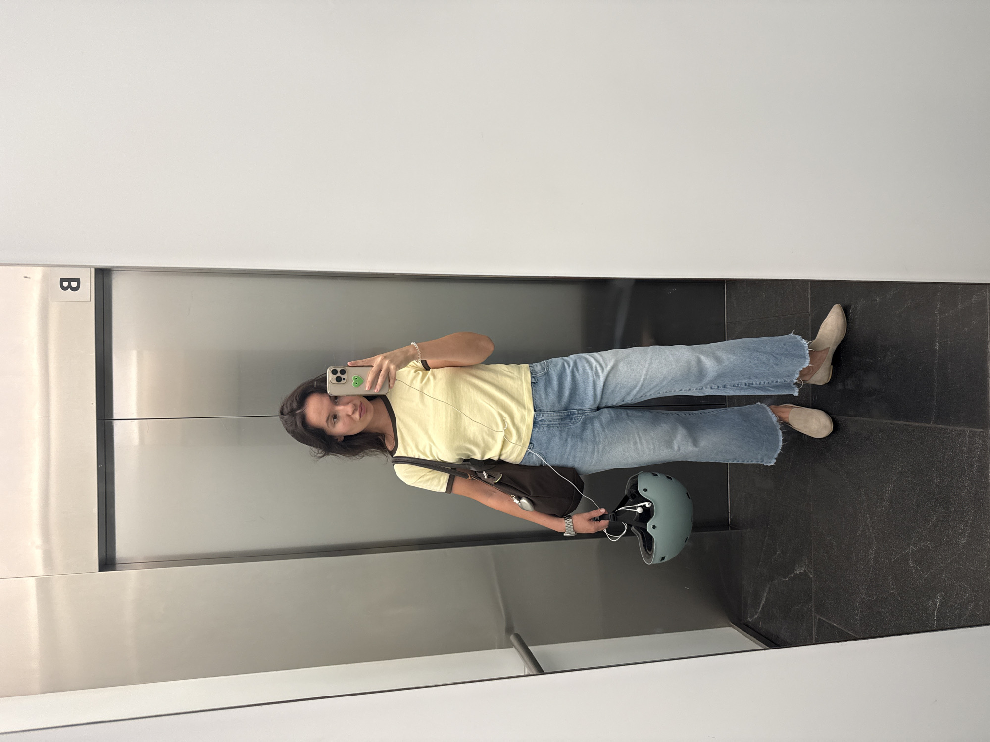 Mirror selfie in a Tel Aviv elevator, casual fit.