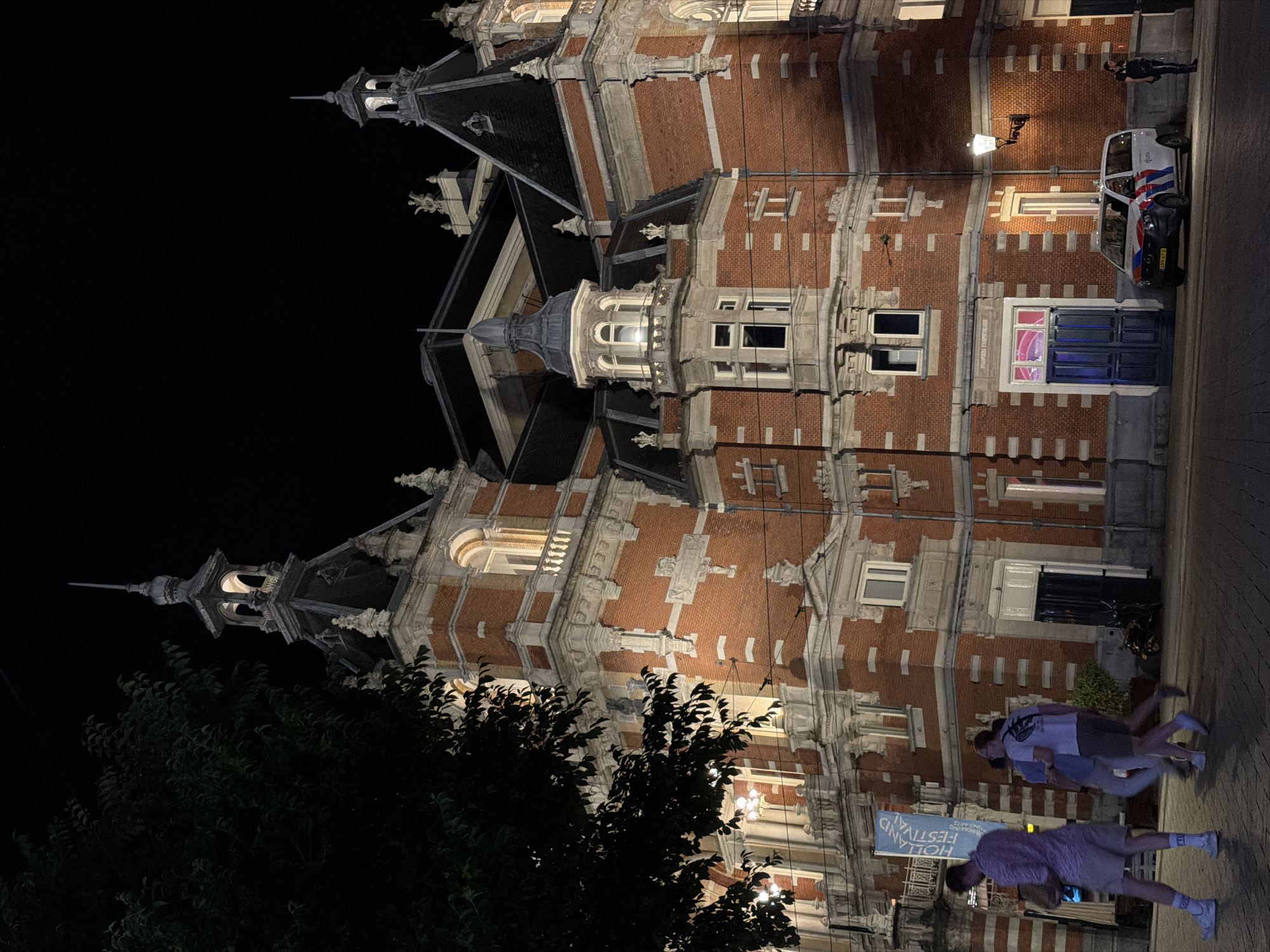 Police presence outside ornate Amsterdam building late at night