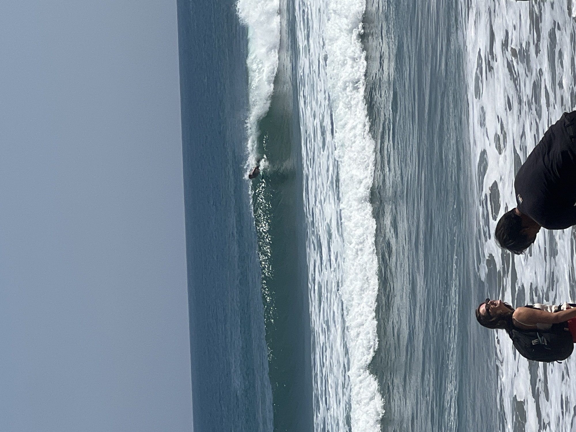 Kuta Beach surf scene with boards, umbrellas, and shoreline activity