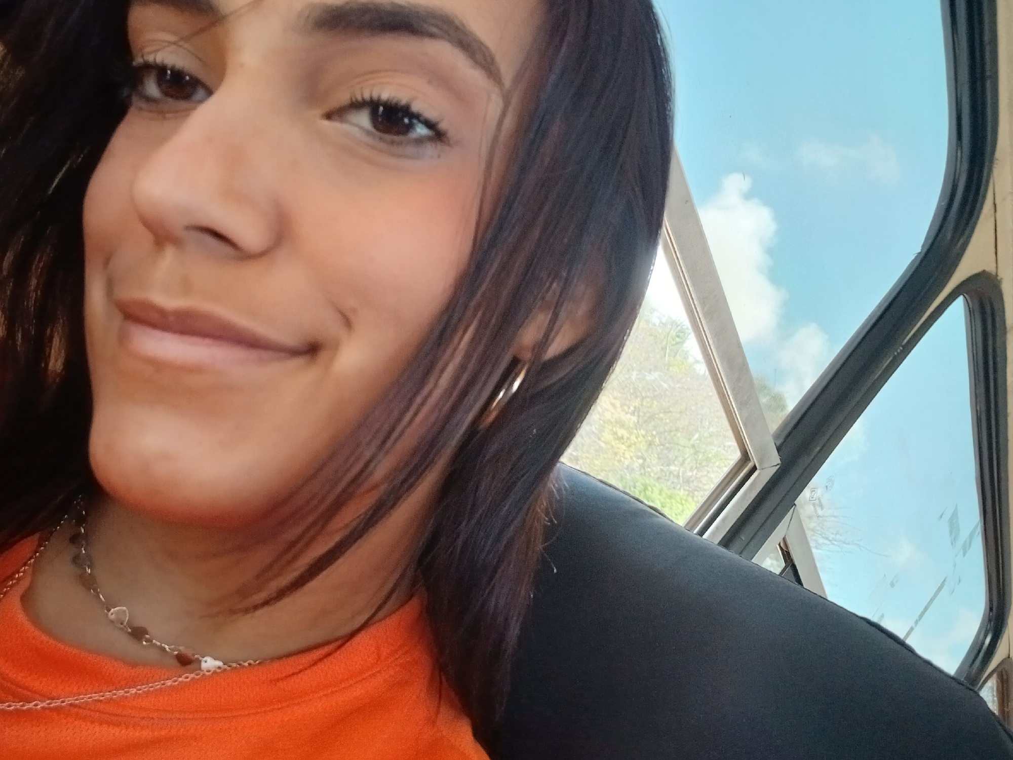 Woman in orange shirt photographed inside vehicle in Venezuela