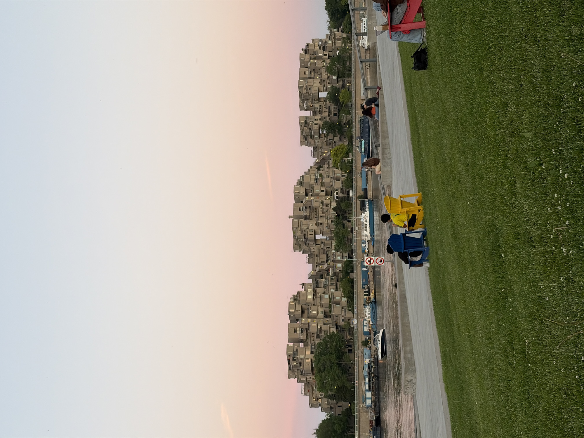 Evening waterfront gathering documented near Montreal's Habitat 67 complex