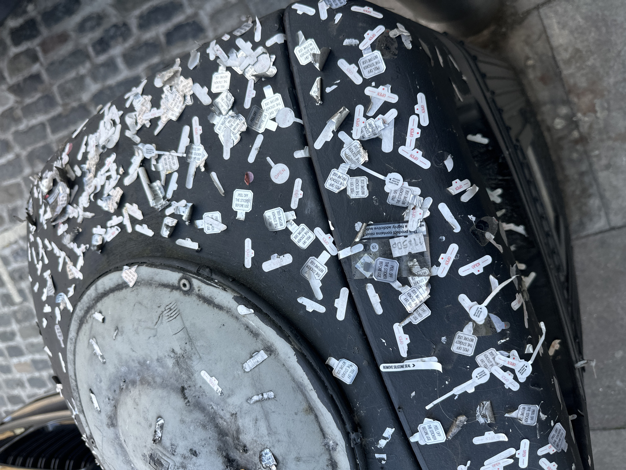 Stickered cylindrical object documented on London street