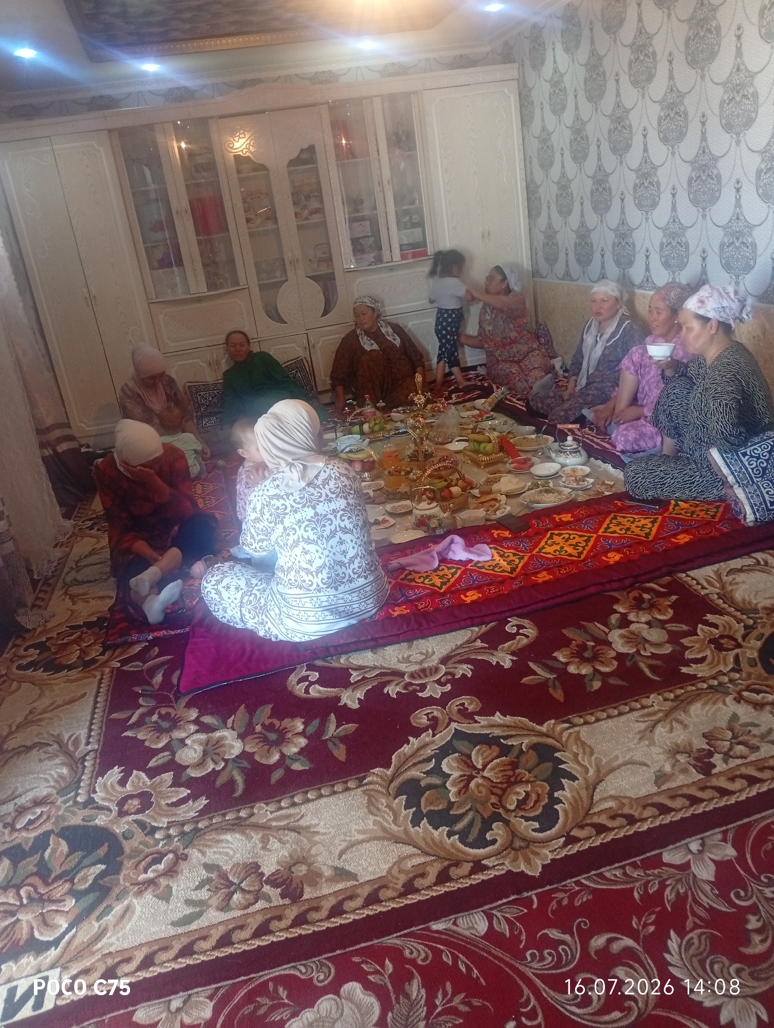 Informal home gathering with food and rugs in rural Kyrgyzstan