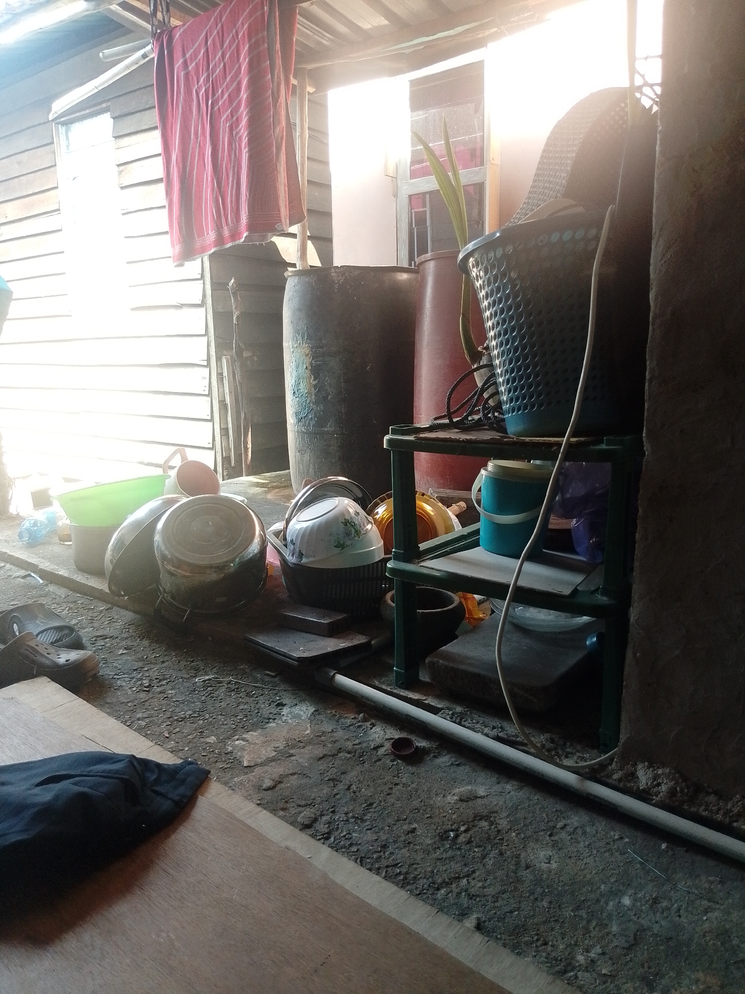 Inside a rough Batam structure, vape juice bottle in hand
