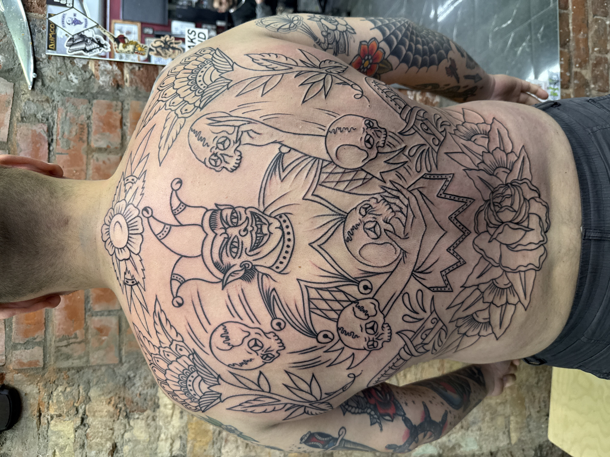 Elaborate tattoo artwork documented in Moscow featuring jester and skulls