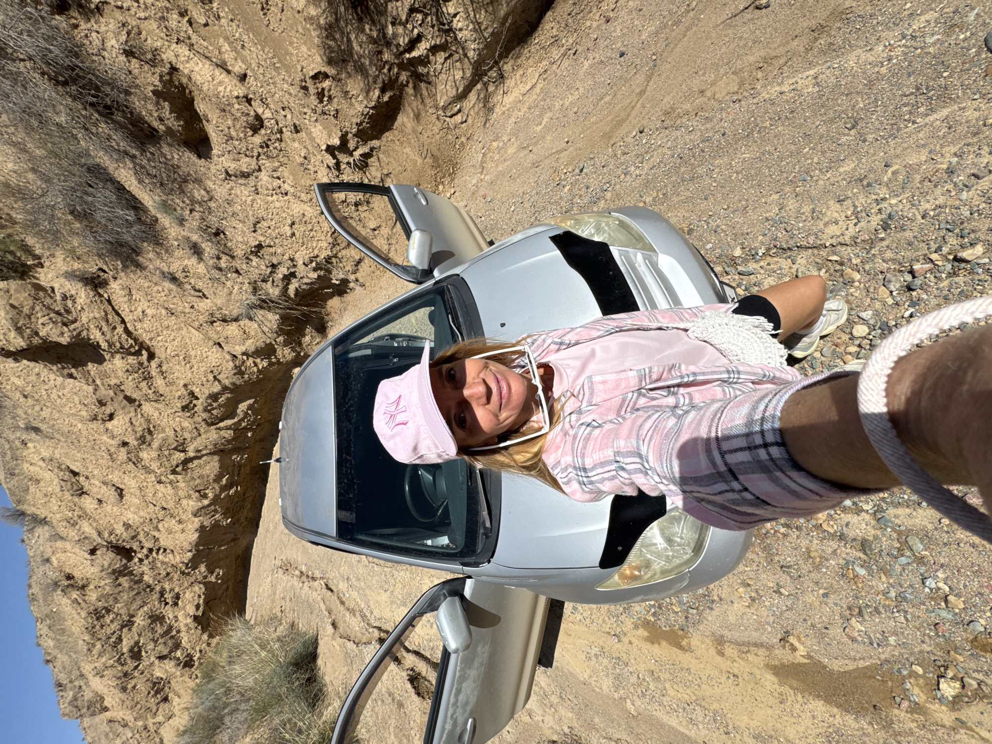 Woman explores Kyrgyzstan canyon terrain during early morning hike