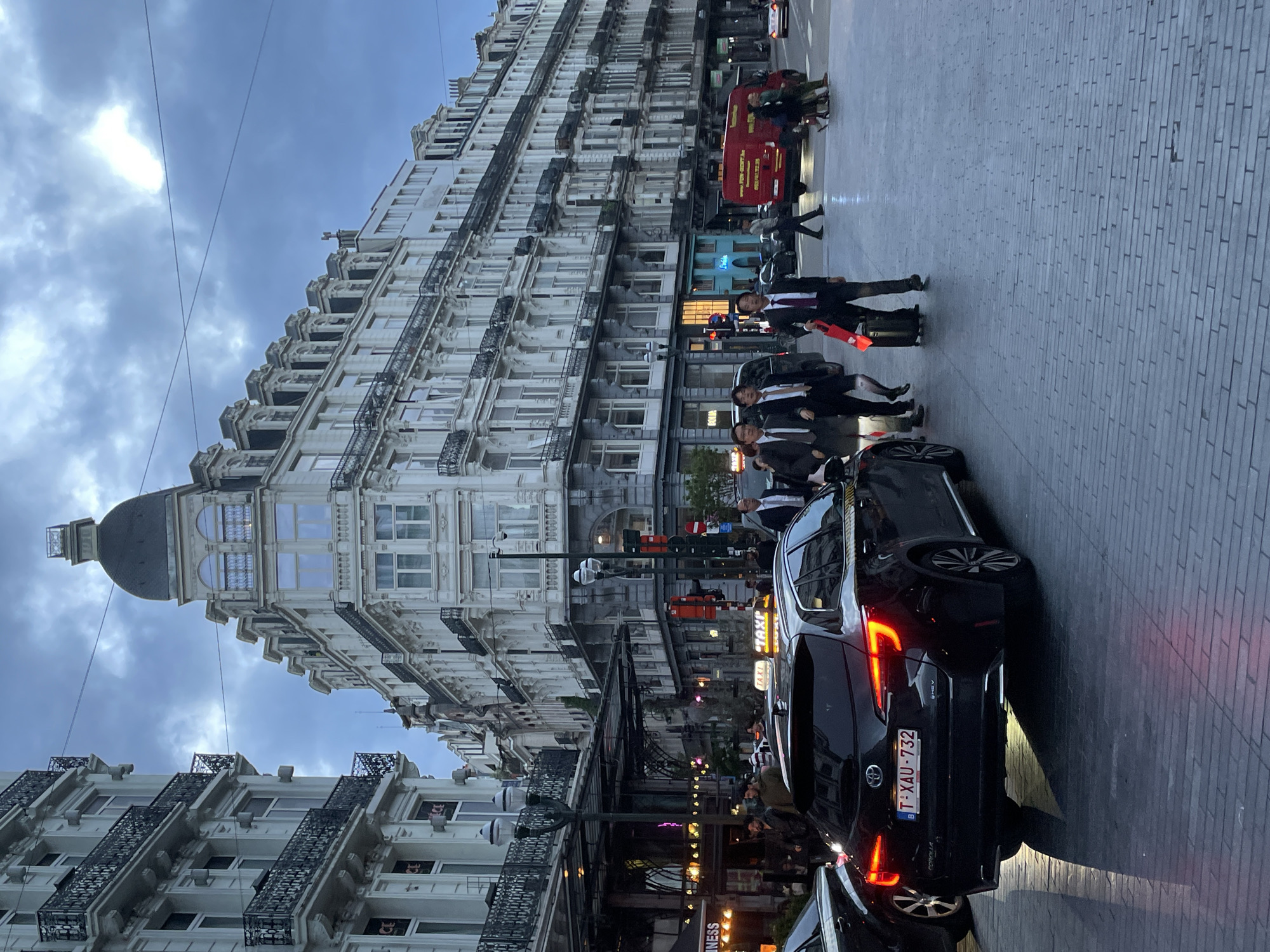 Evening street life captured around Brussels Bourse during twilight