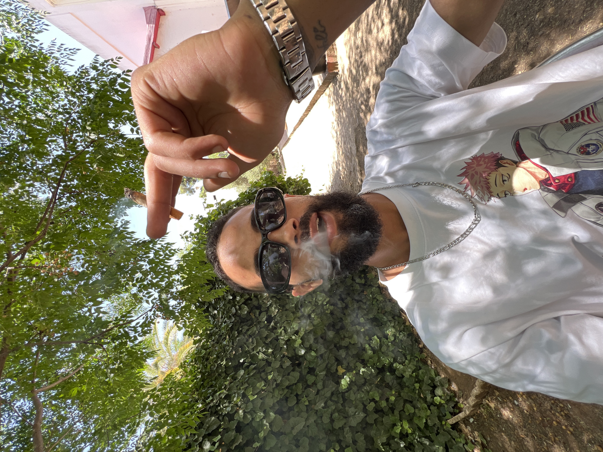 Man photographed smoking in garden setting, Meknes Morocco