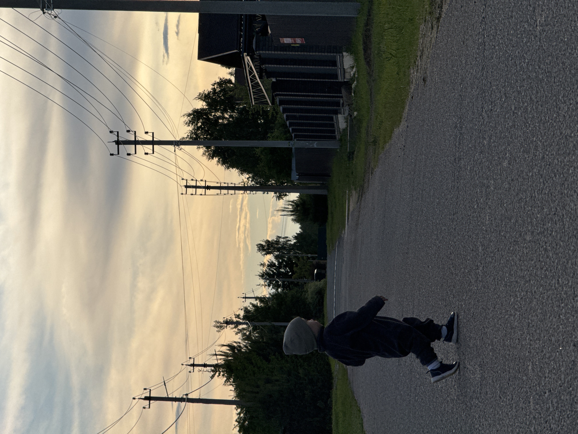 Two pedestrians walk along rural road in Vysokinichi, Russia