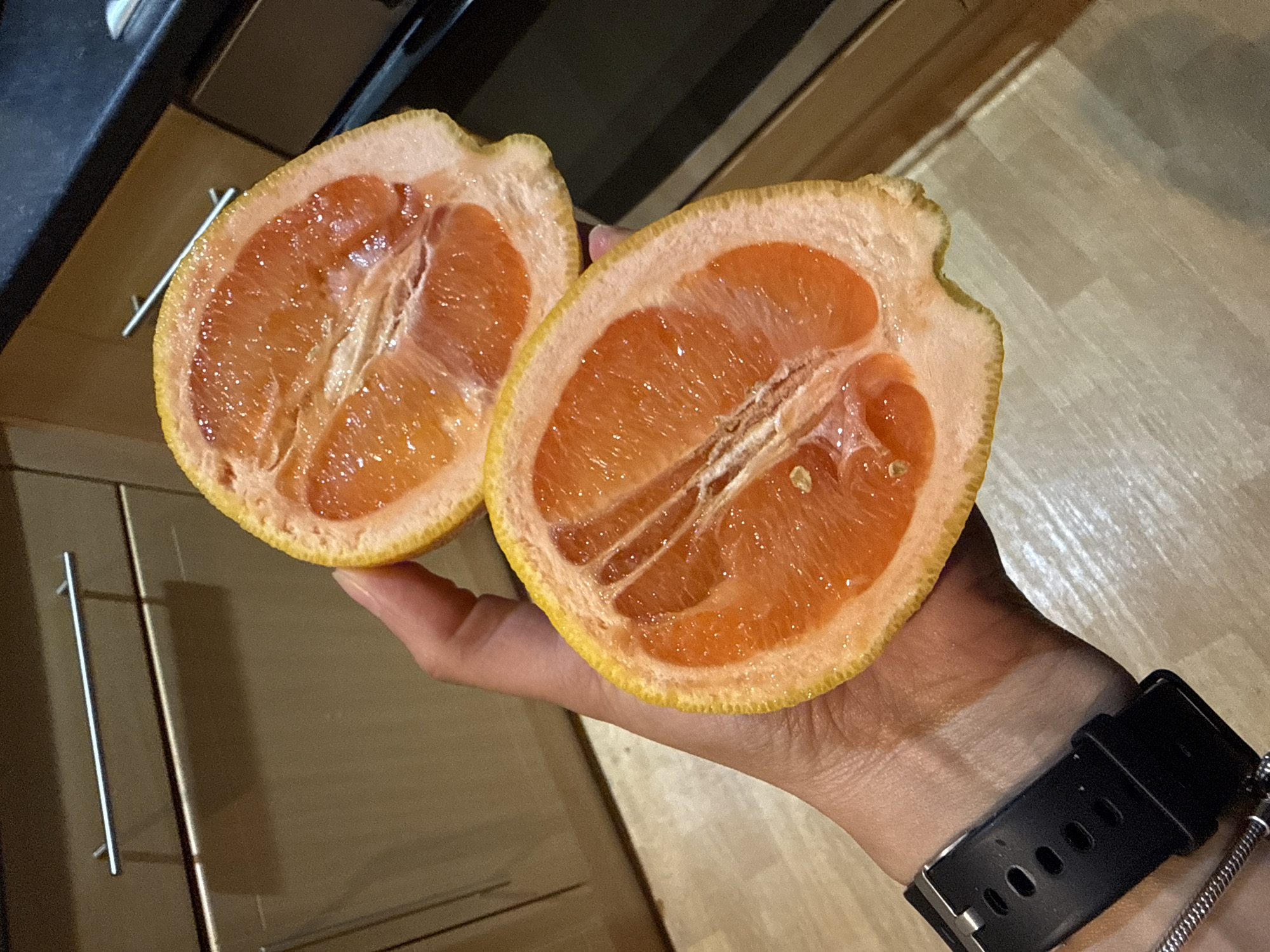 Person holds halved grapefruit indoors in Great Yarmouth