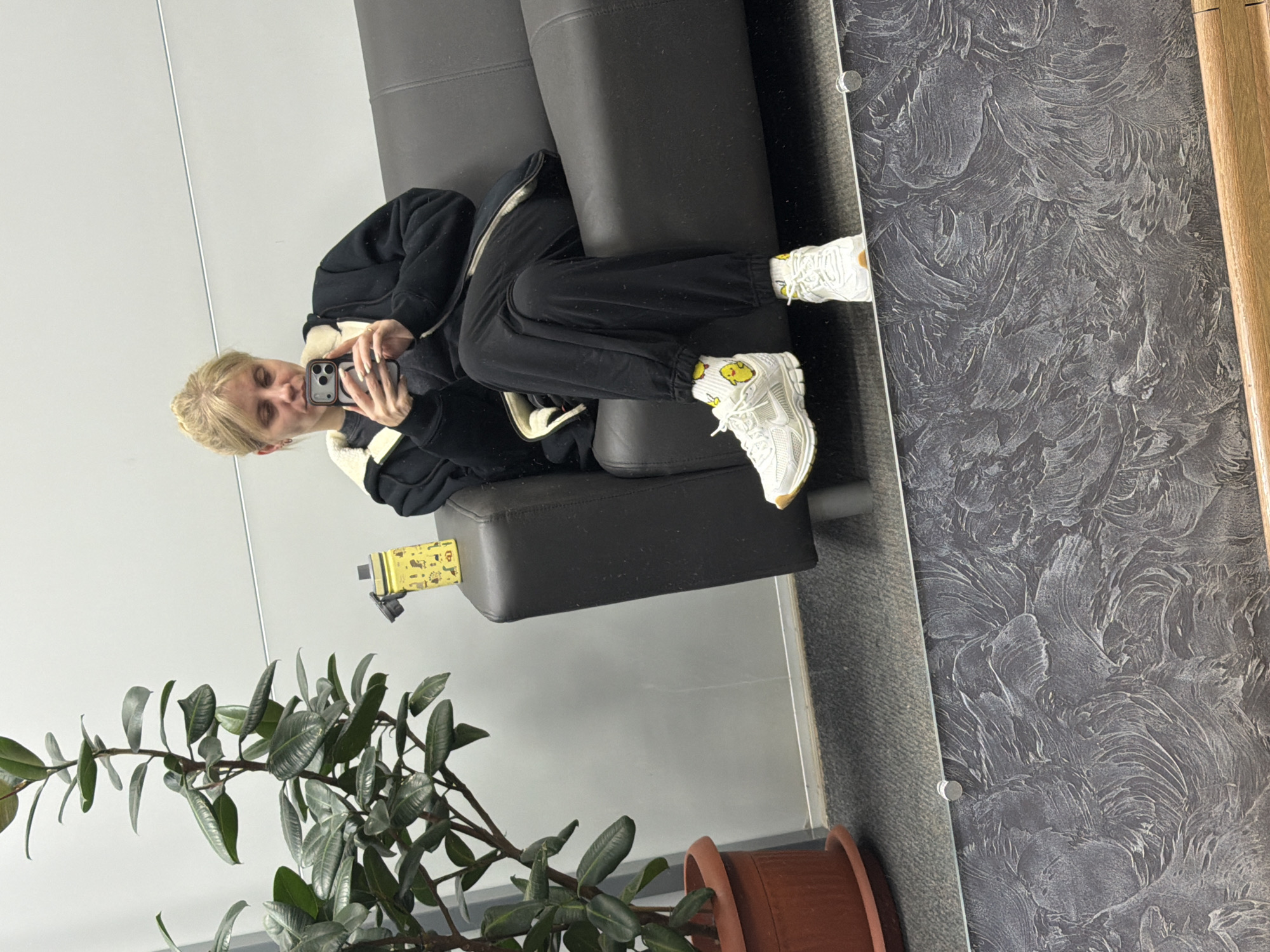 Person photographed using smartphone on couch in Chaikovsky residence