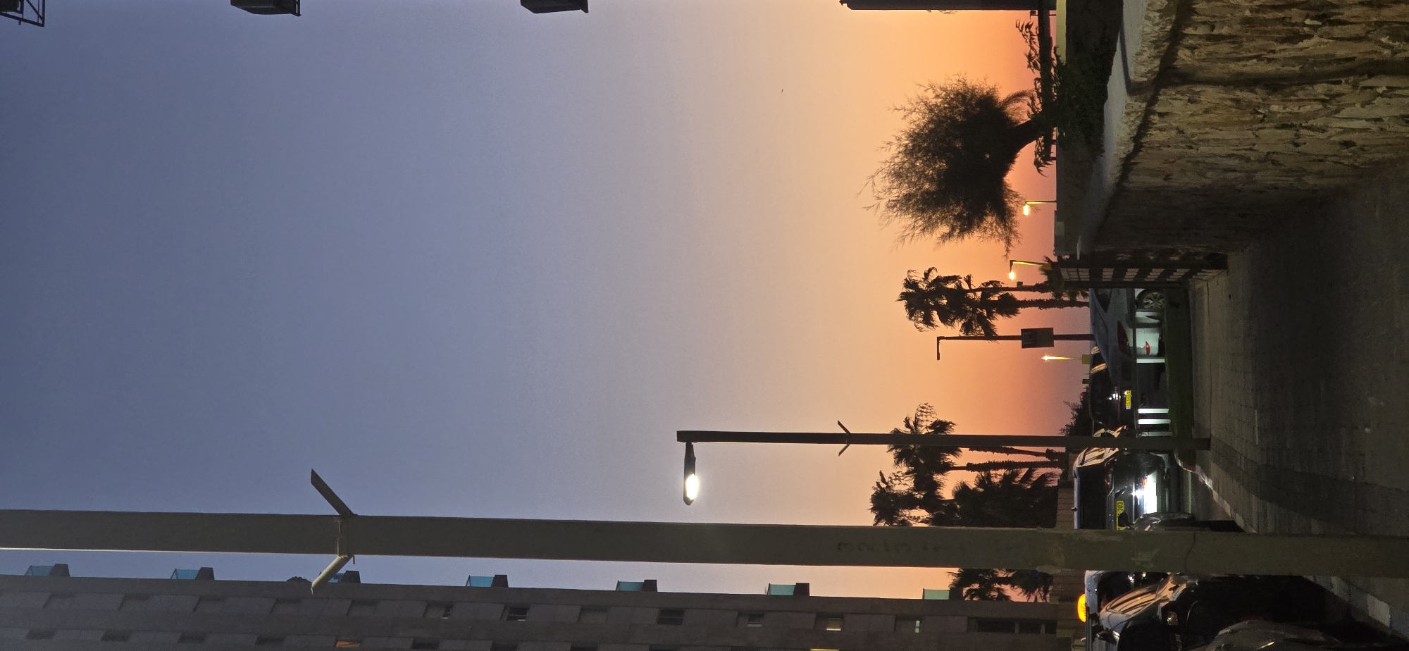 Bat Yam at dusk: tram, twilight skies, and city streets