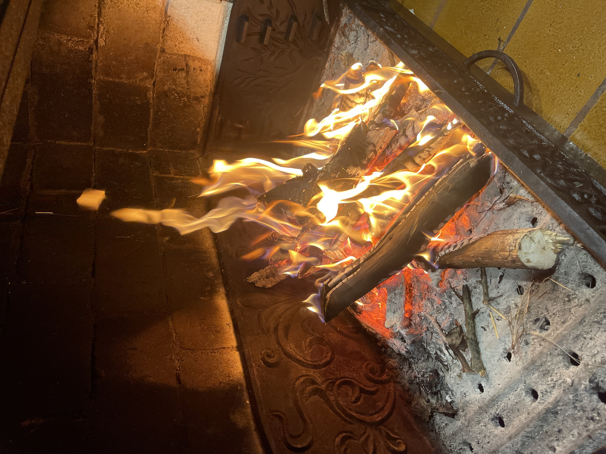 Crackling log fire burning in an outdoor fireplace at night