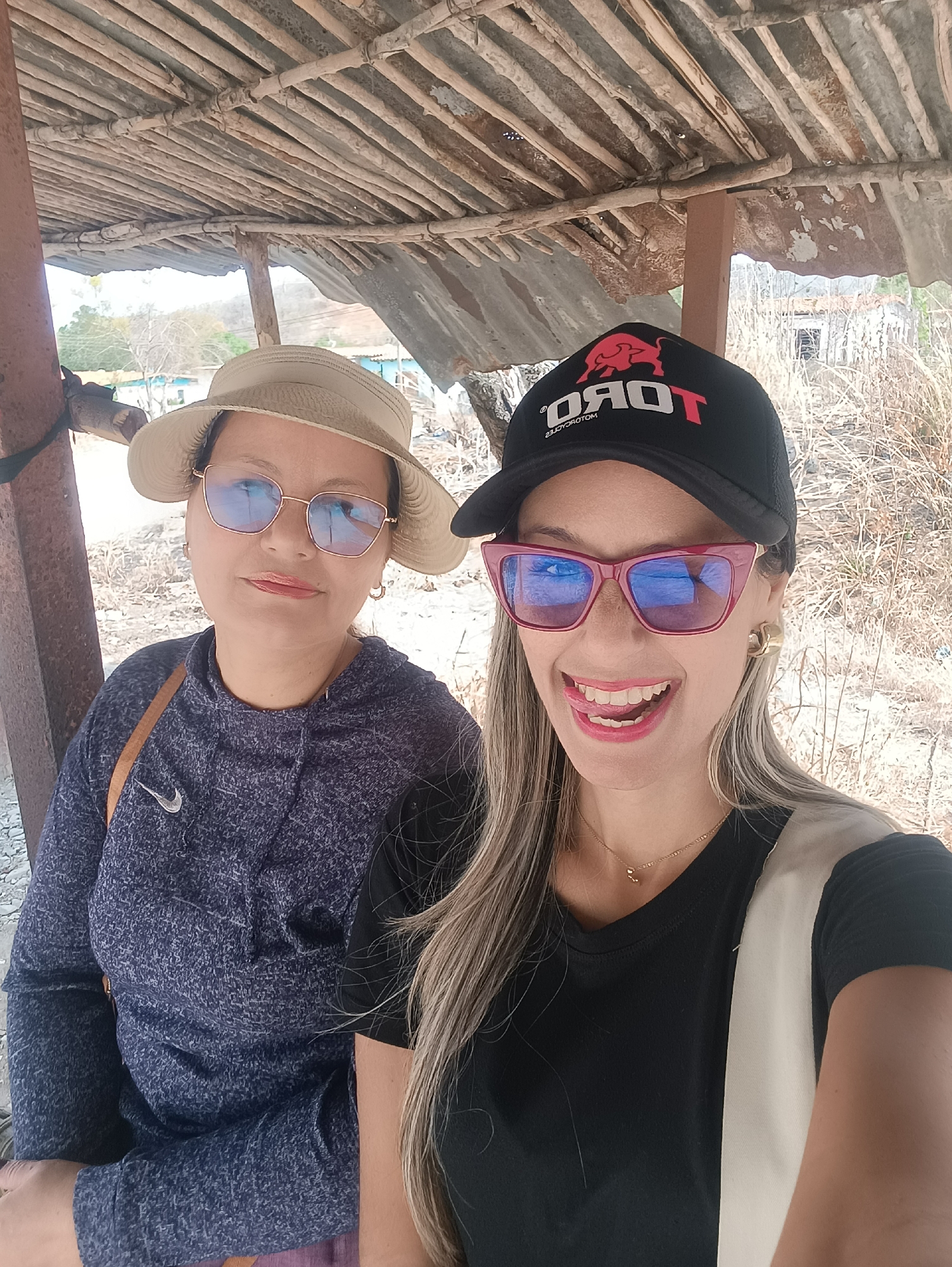 Two women pose for photo under shelter in La Pica