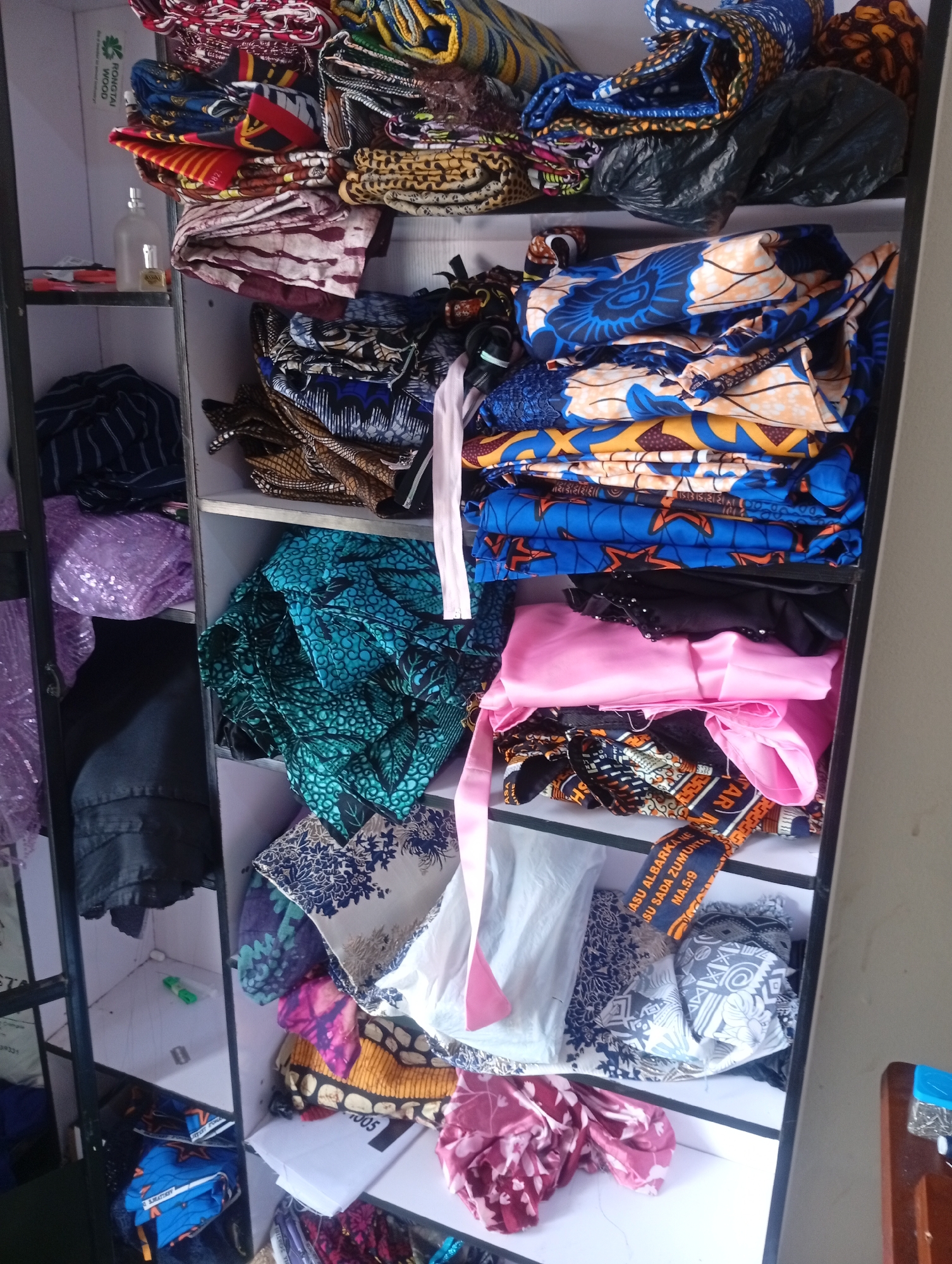 Inside a Jalingo tailor's workspace, fabrics and sewing gear on display