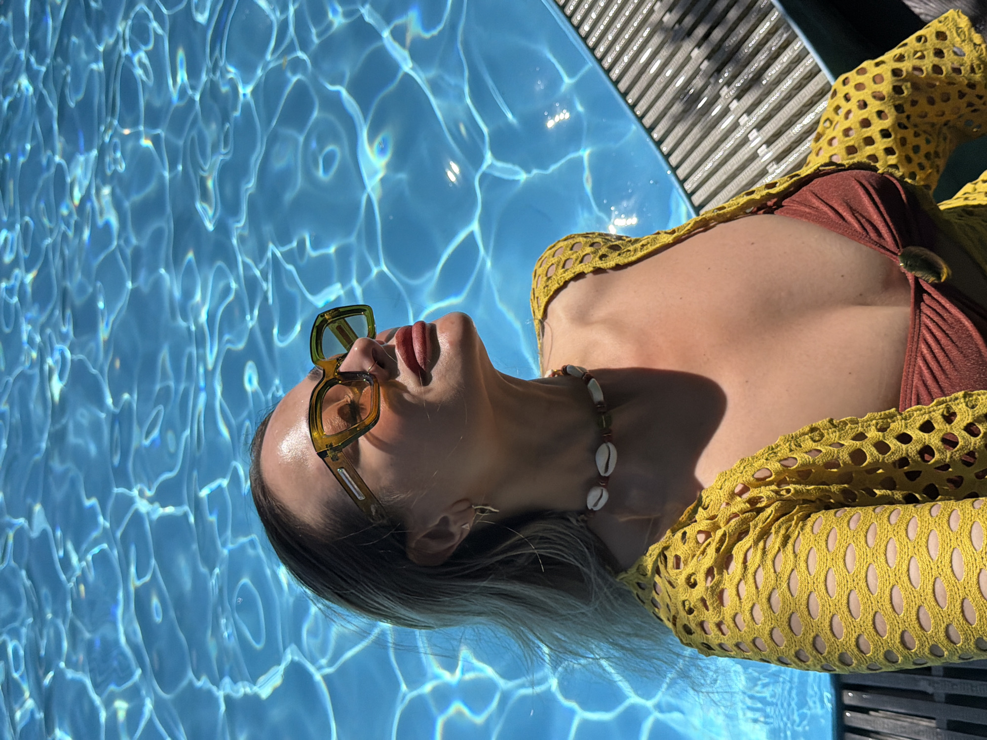 Woman enjoys sunny morning poolside relaxation in Krasnoyarsk