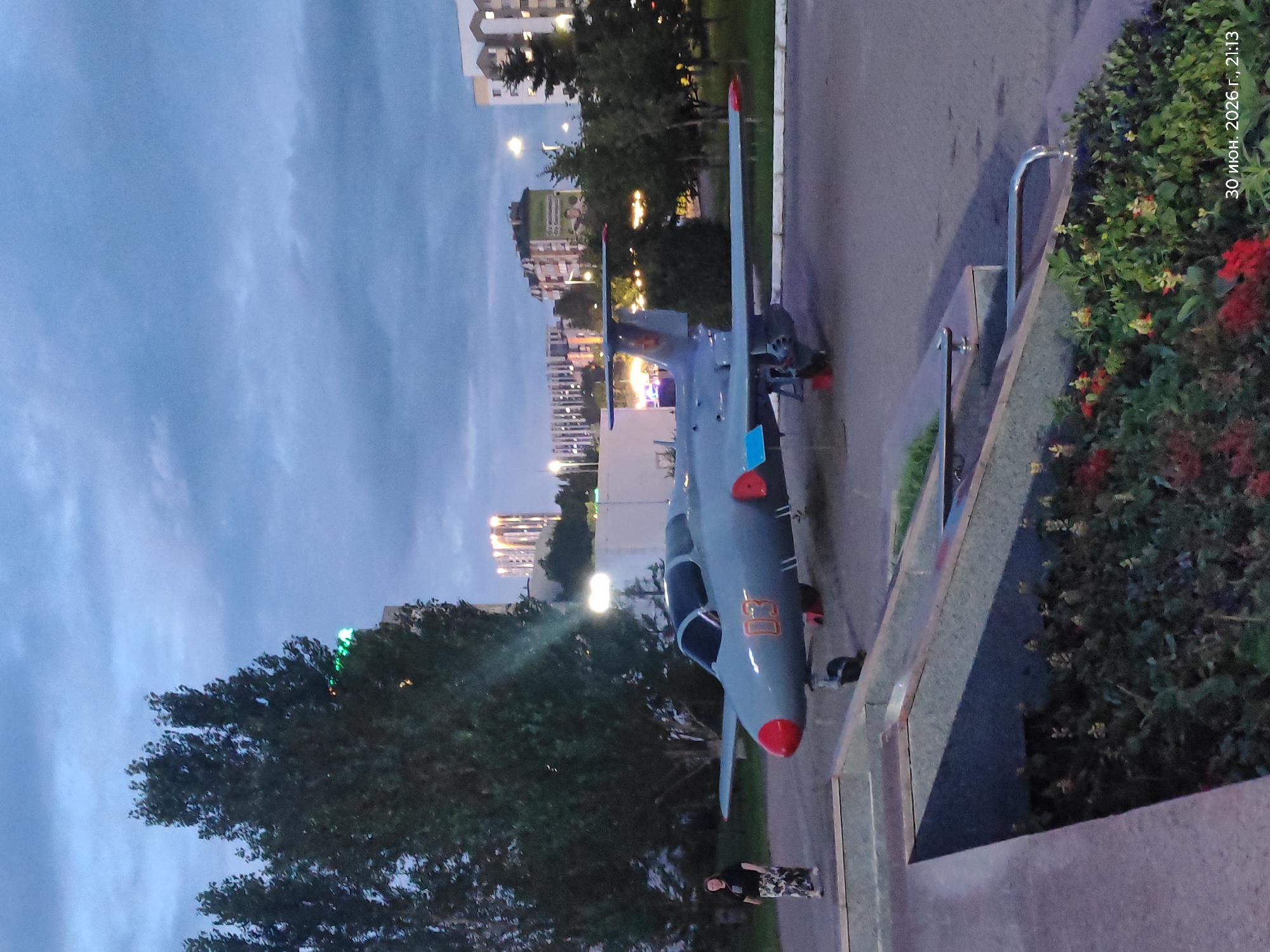 Outdoor military hardware display and city streets at dusk, Astana