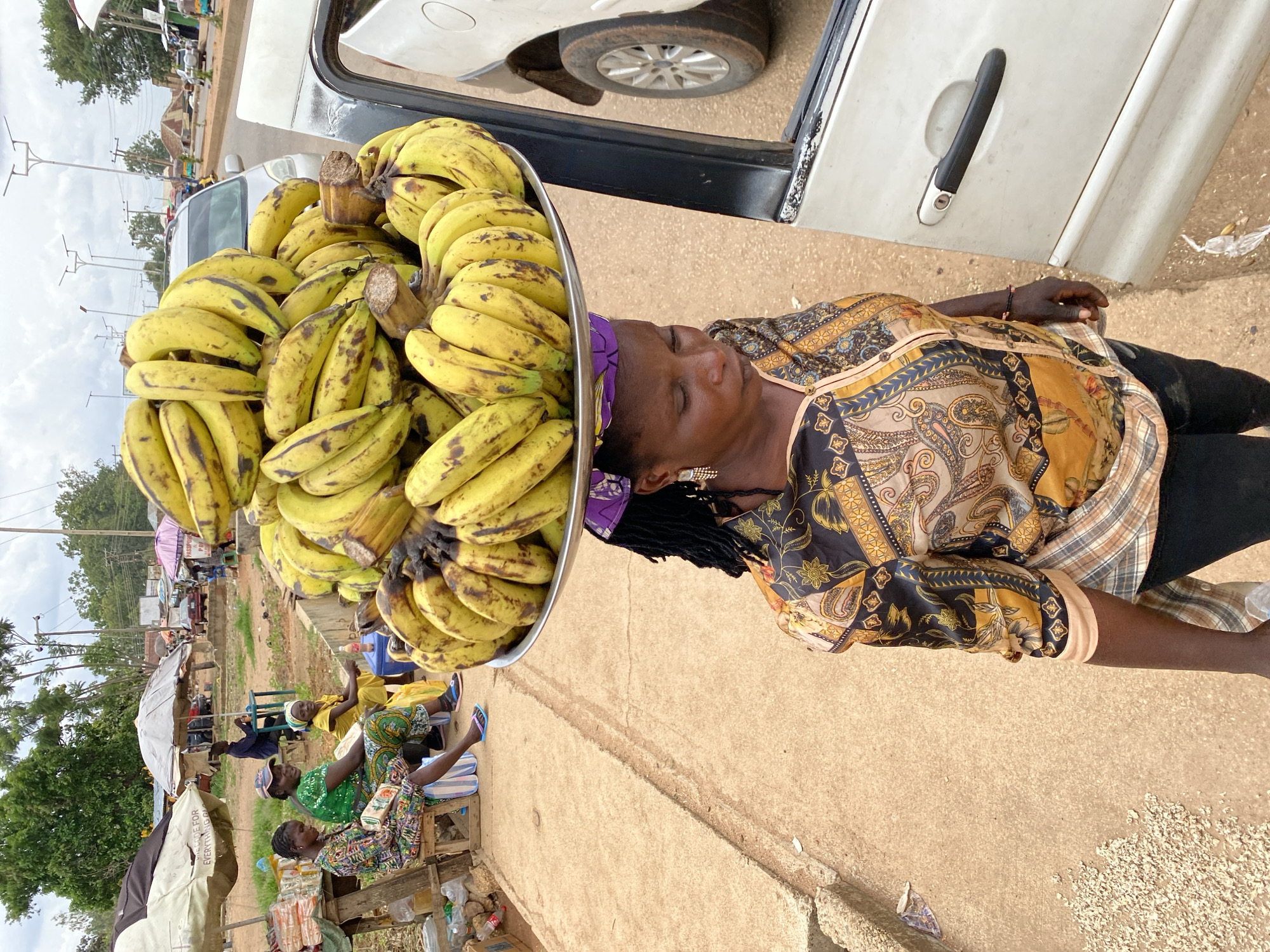 Bukuru street life: vendors, rickshaws, and road traffic midday