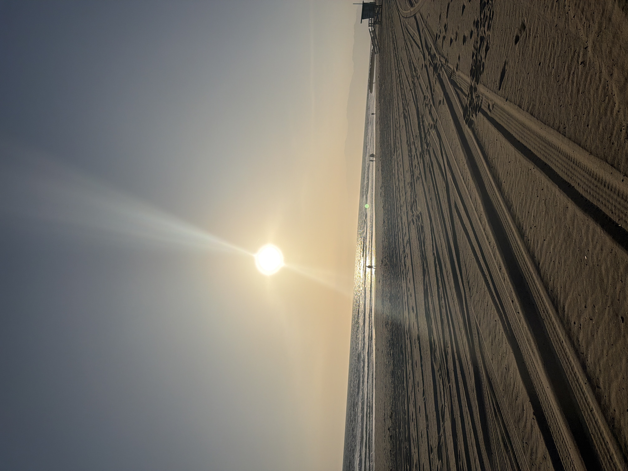 Beach activity captured in Los Angeles with tire tracks