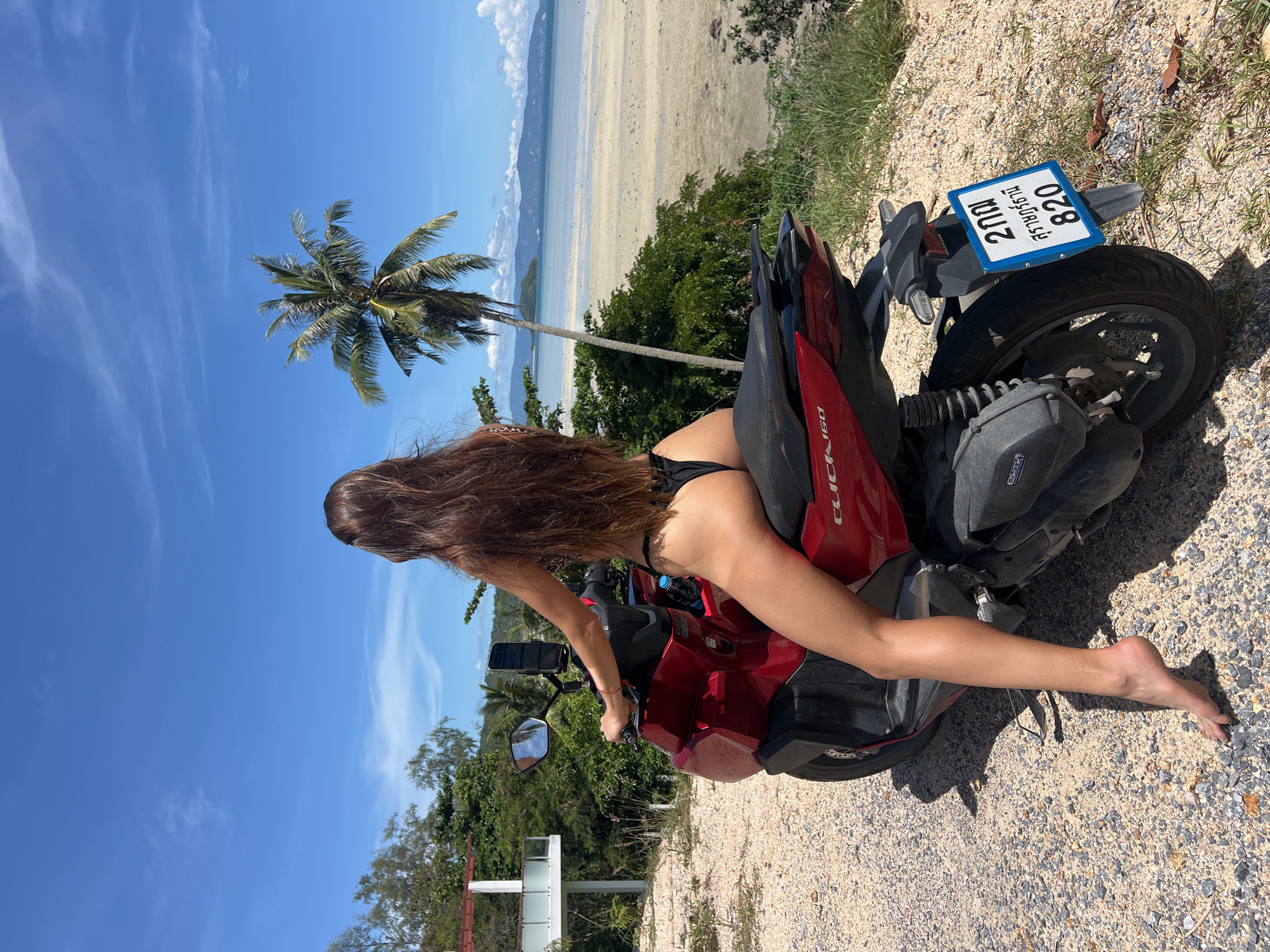 Red scooter parked beachside on Koh Phangan, June morning